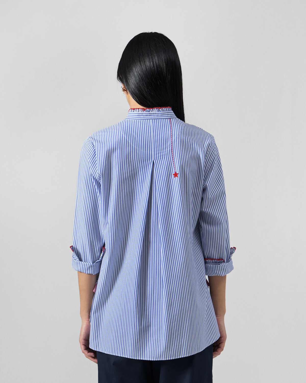Back of a blue and white striped Sora ruffle shirt with a red star.