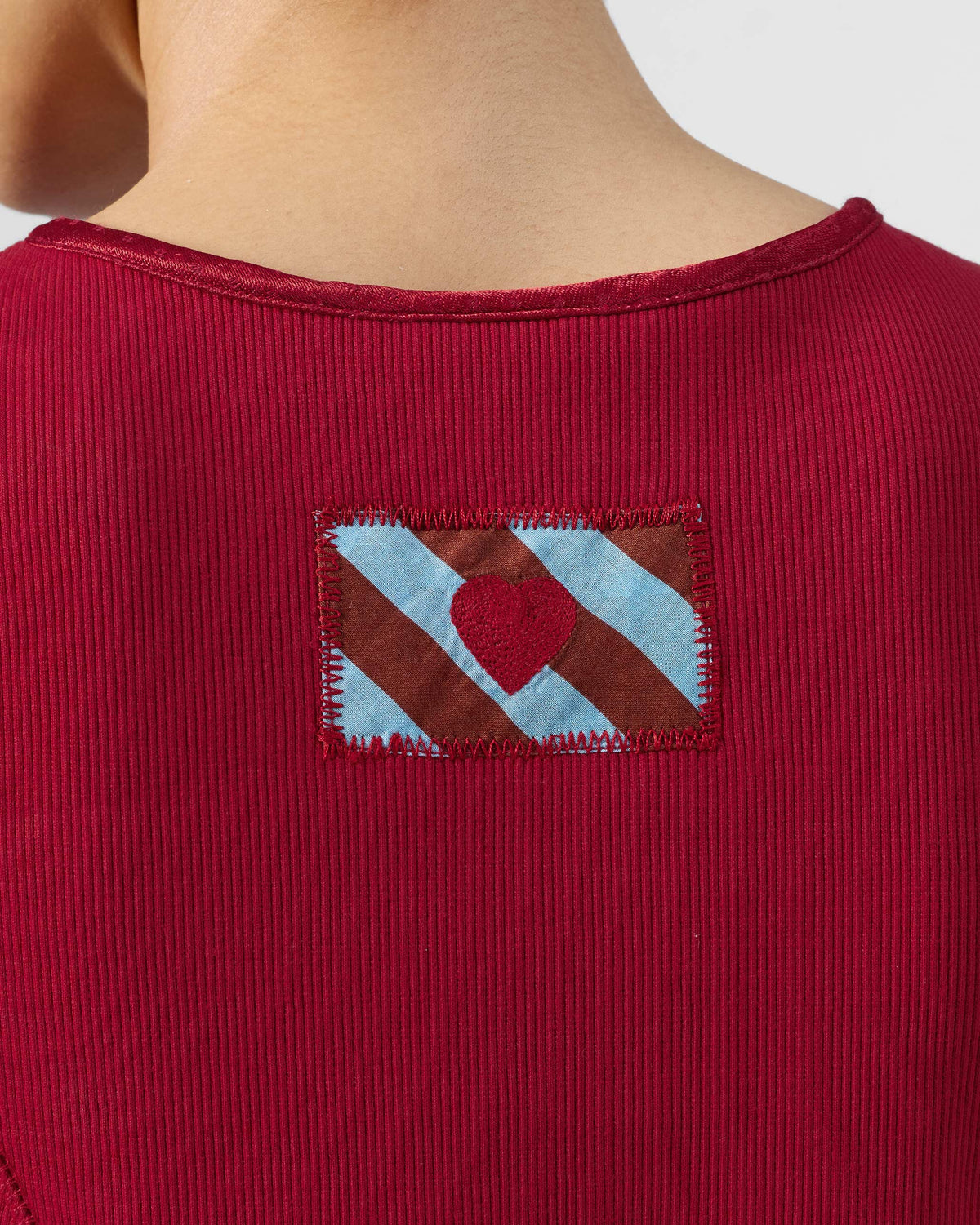 Close-up of a striped heart patch on a red Norva skater dress.