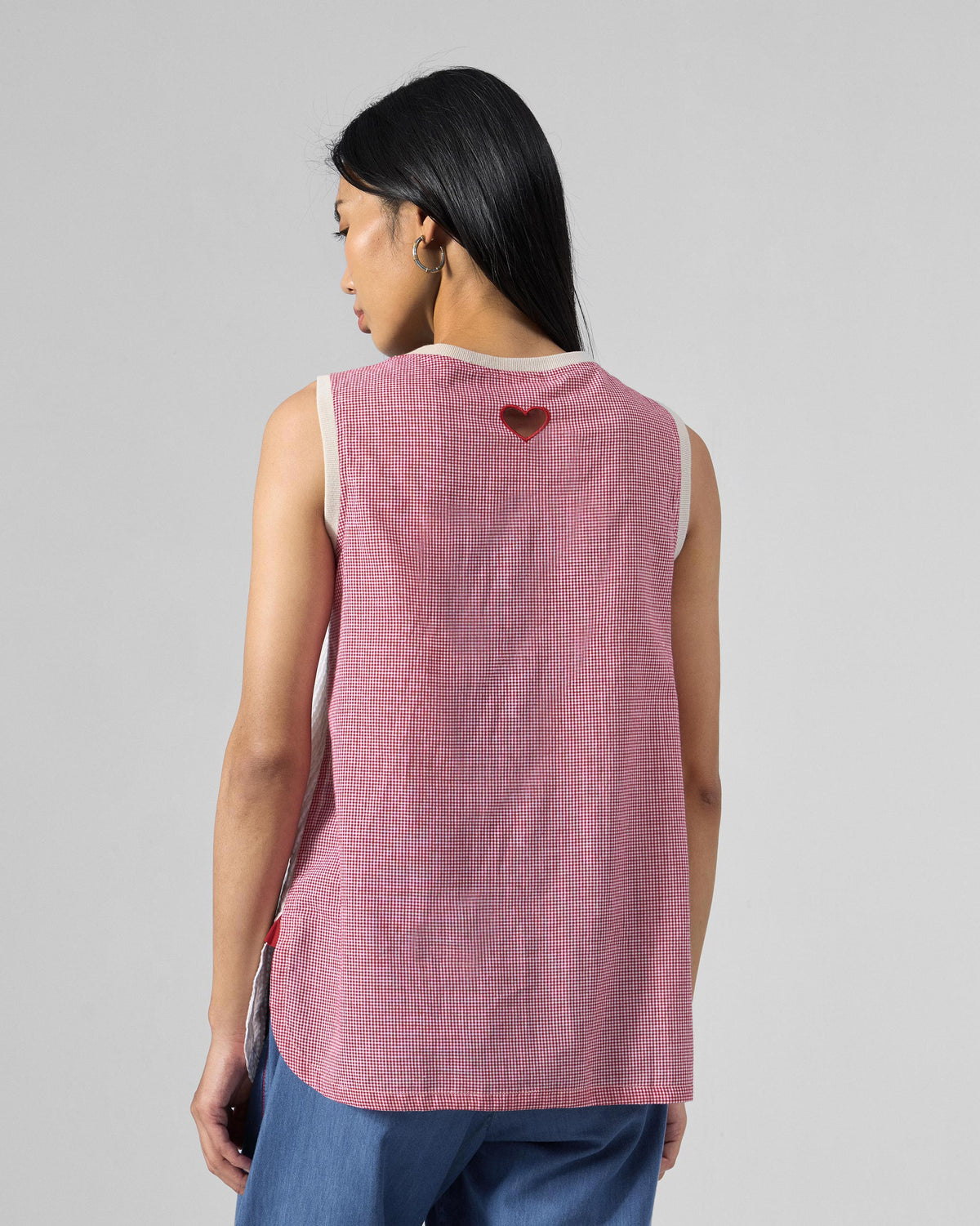 Back of a pink checked seersucker top with a red heart at the neck.