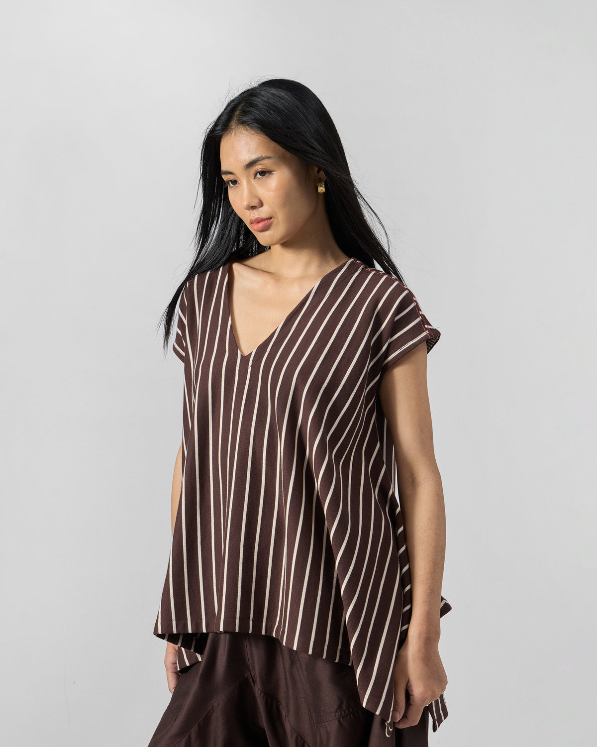 Person wearing a brown and ivory striped Nera kaftan top.