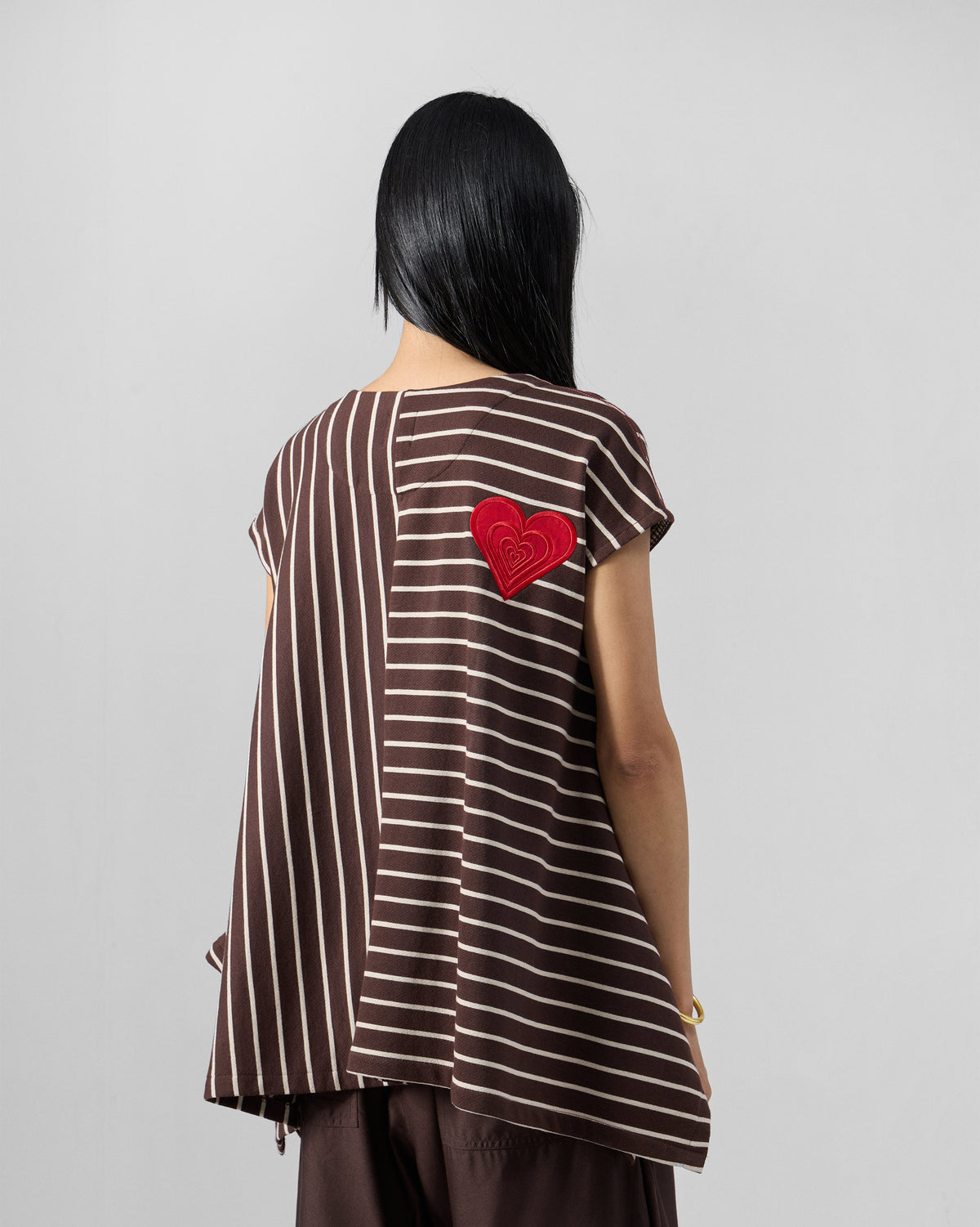 Back of a brown and ivory striped Nera kaftan top with a red heart.
