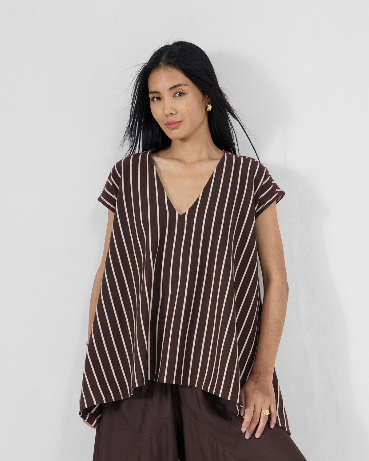 Person wearing a brown and ivory striped Nera kaftan top.