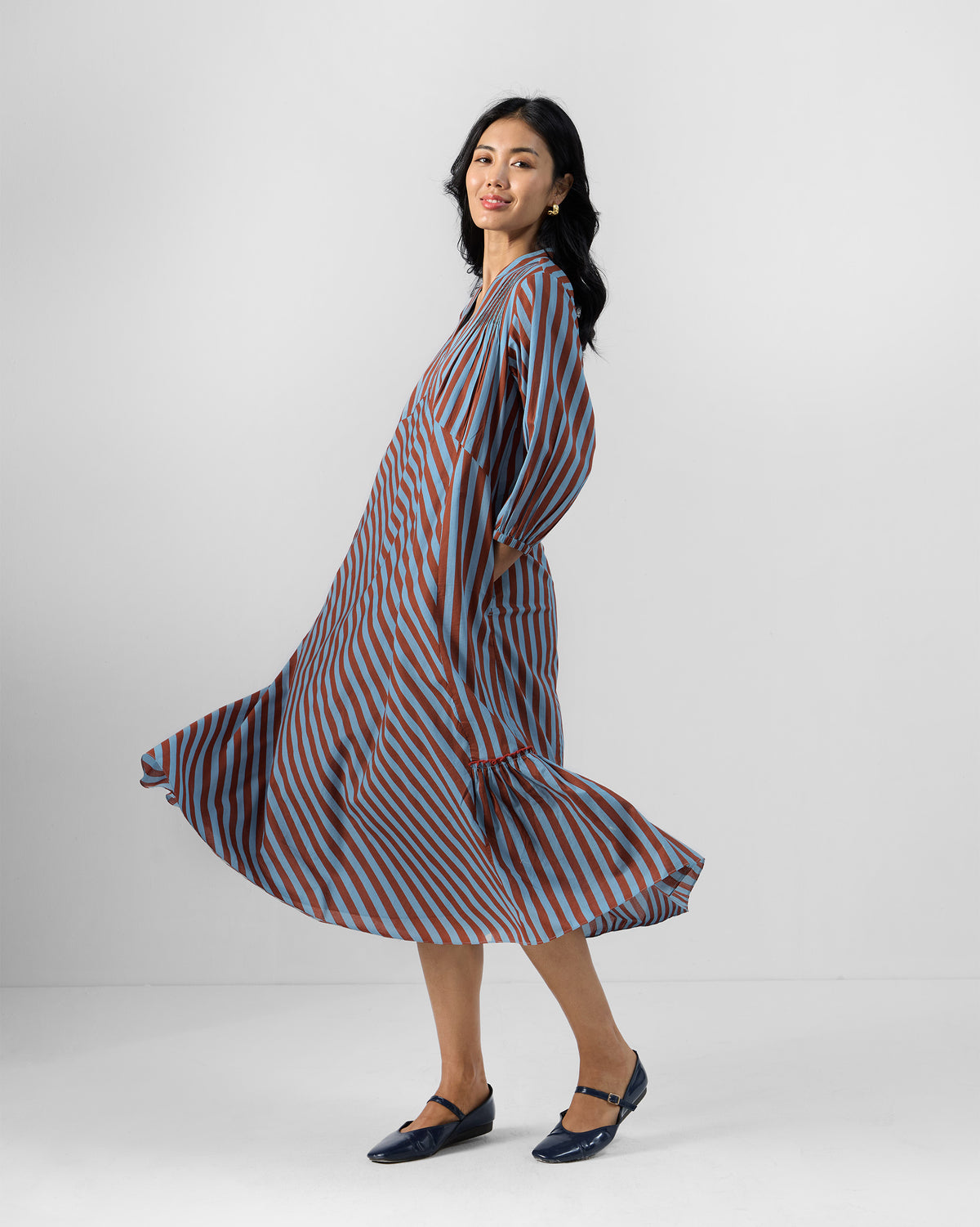 Person twirling in a blue and brown striped Summer Tea dress.