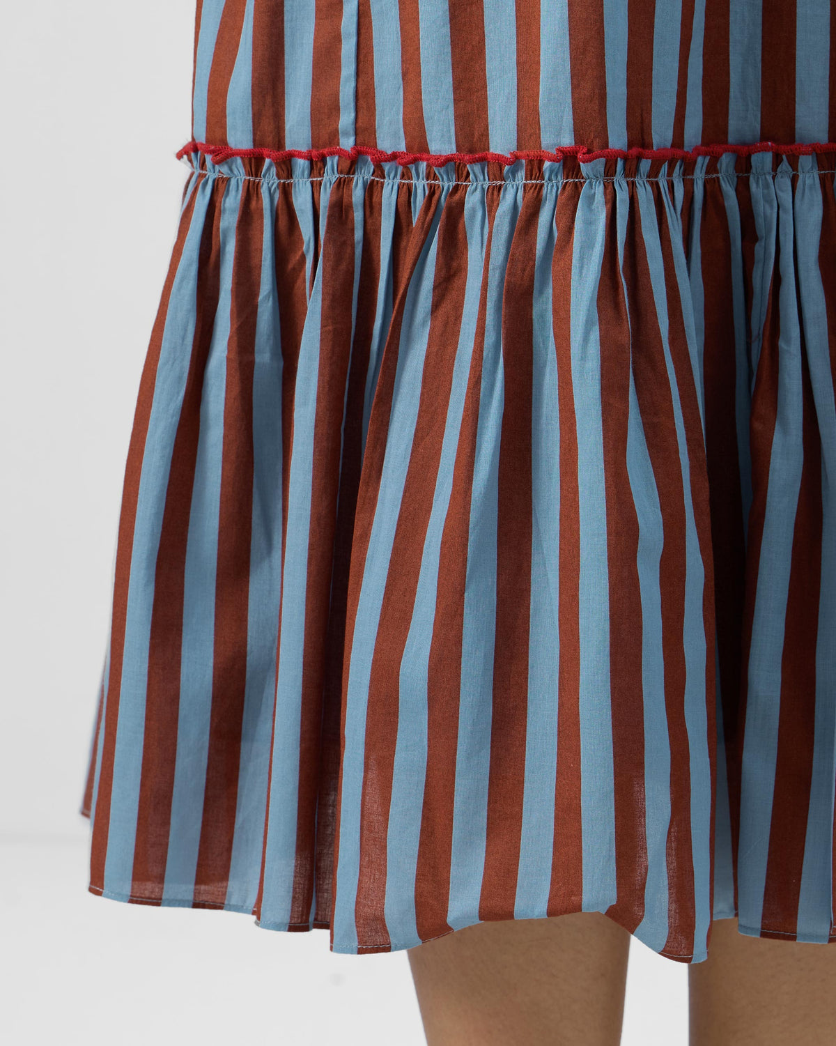 Close-up of the ruffled tier on a blue and brown striped Summer Tea dress.