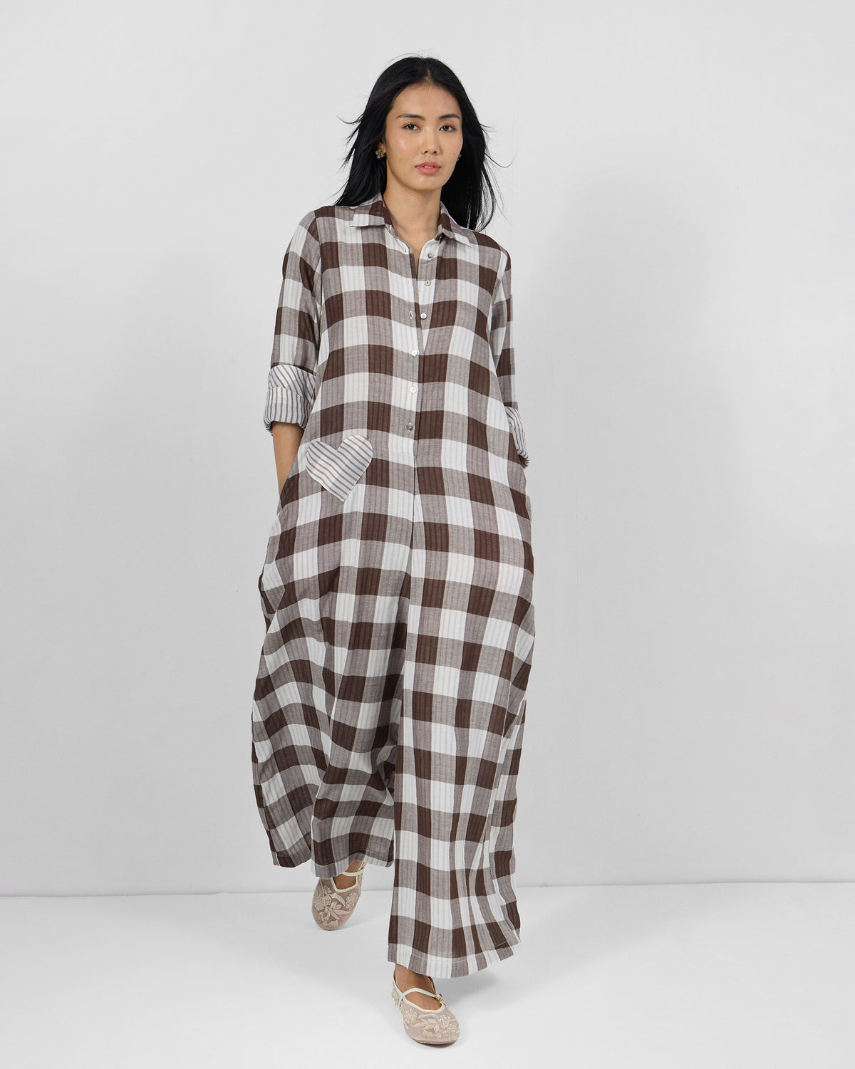 Person wearing a brown and ivory check jumpsuit with a heart-shaped patch pocket.