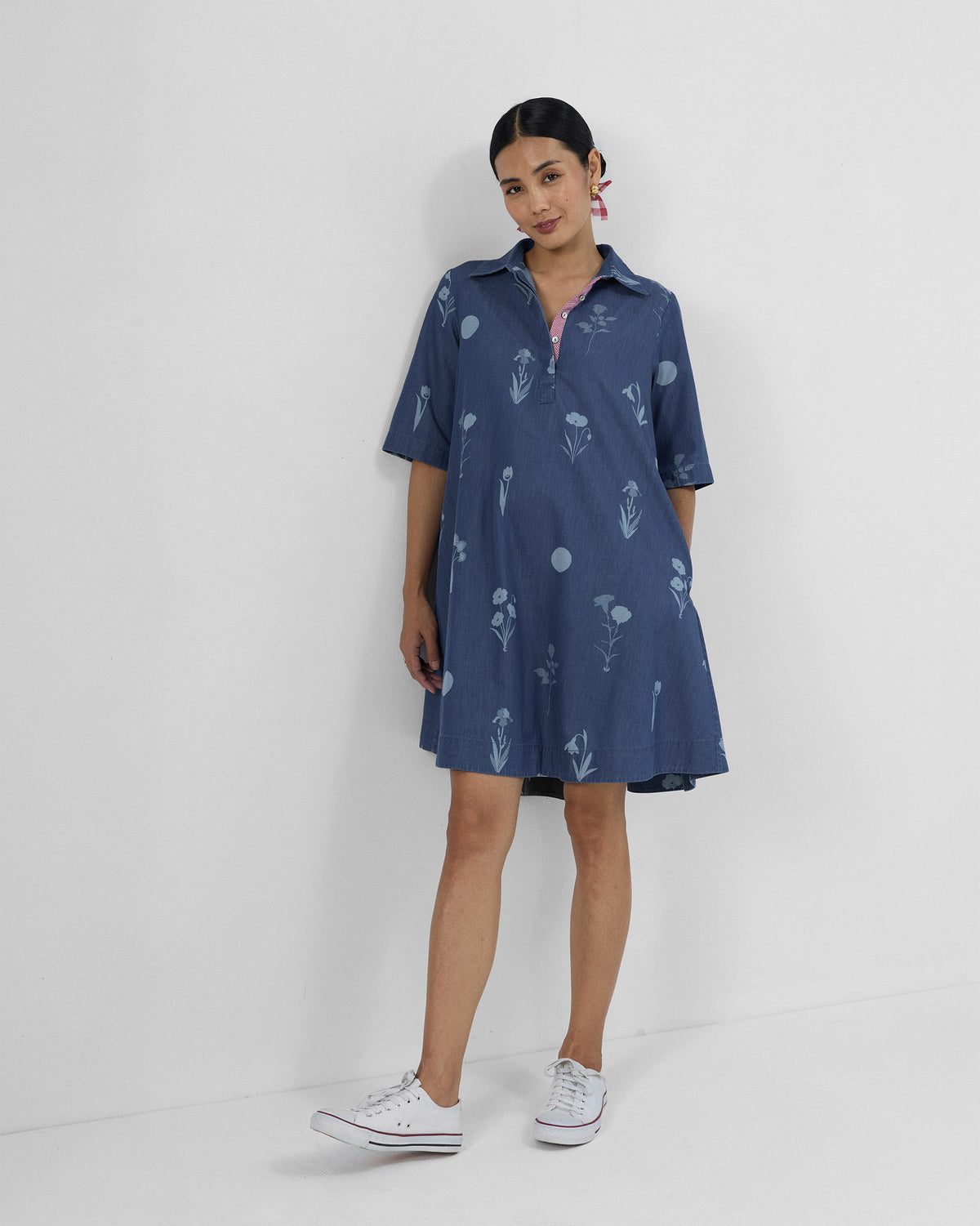Person wearing a blue Happy Heart shirt dress with light floral motifs.