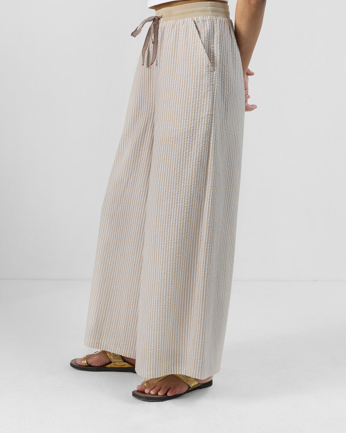 Three-quarter view of brown and ivory Hera Pants showing the flared fit.