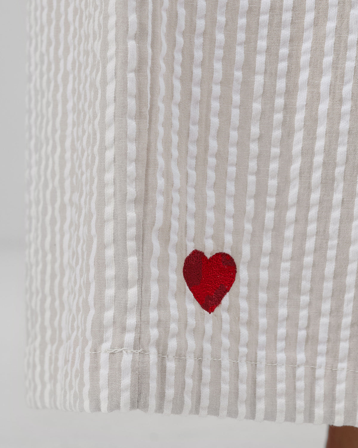 Close-up of Hera Pants seersucker stripes with a small red embroidered heart.