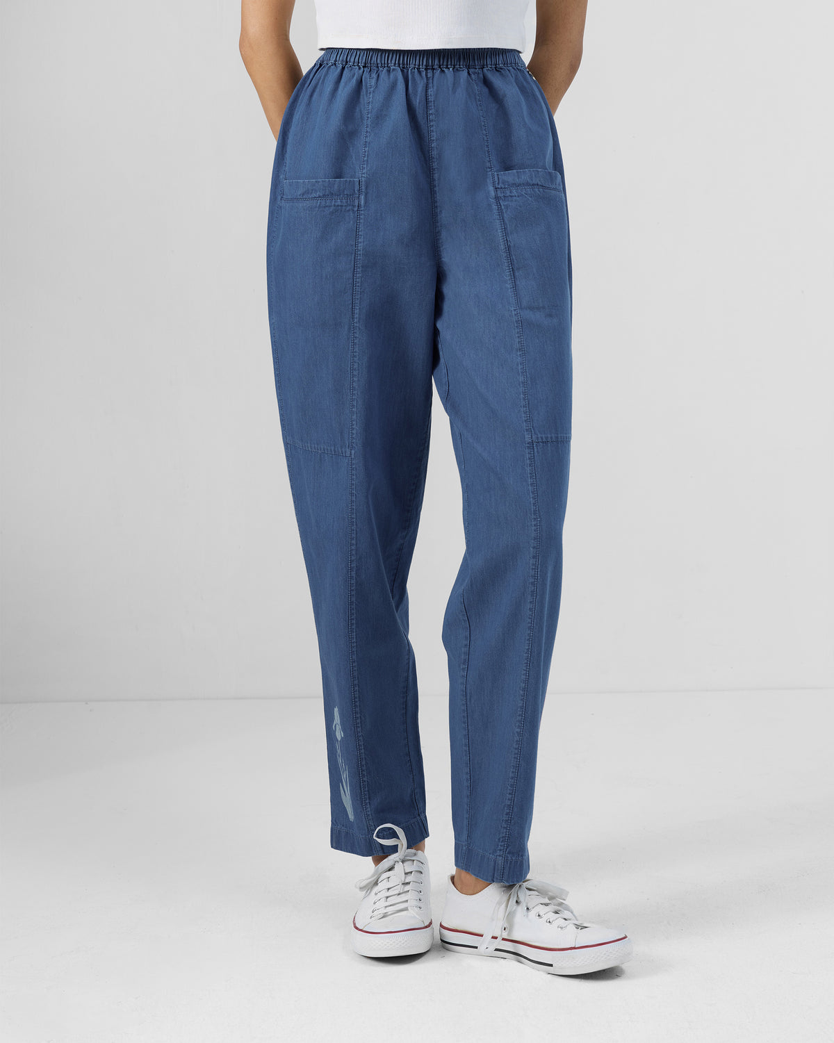 Person wearing blue Kaiteki Pants with patch pockets and a gathered waistband.