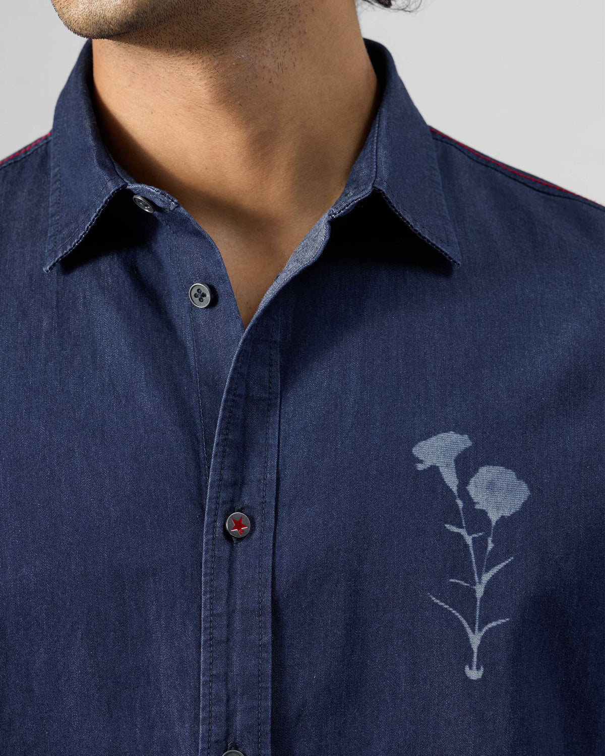 Close-up of an indigo denim Classic shirt with a floral chest print.