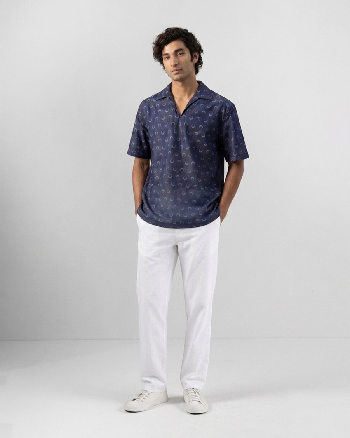 Person wearing an indigo moon-print Yamuna kurta shirt with white trousers.