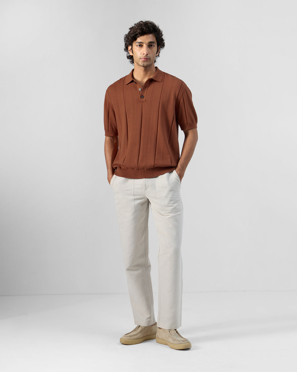 Person wearing a rust Abeer polo t-shirt.