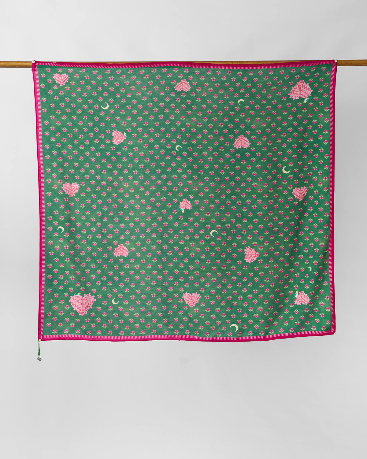 Gulnaar scarf hung flat, showing pink flowers and crescent moons on green.