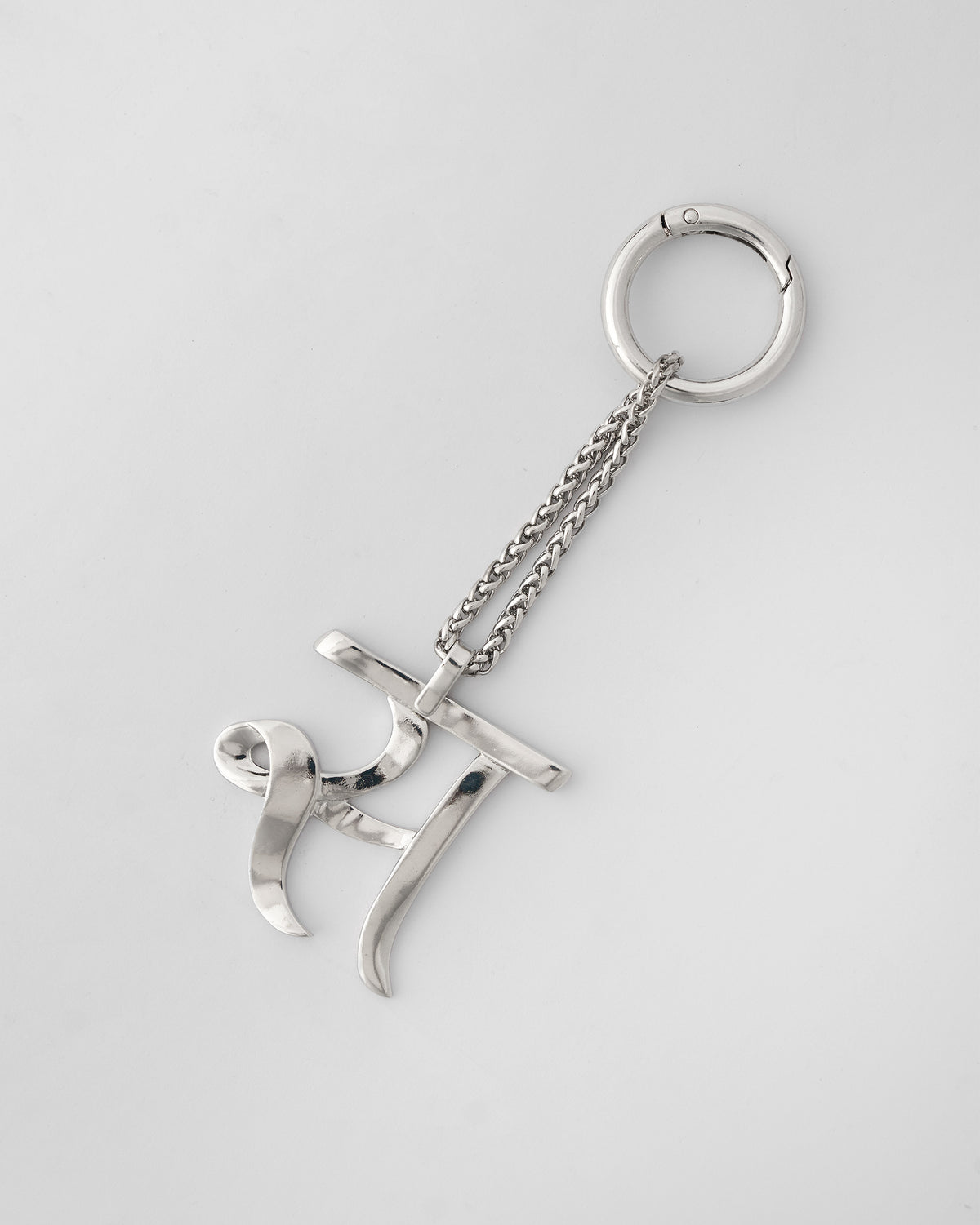 Alphabet S Bag Charm in silver, with chain and clasp ring on a light background.