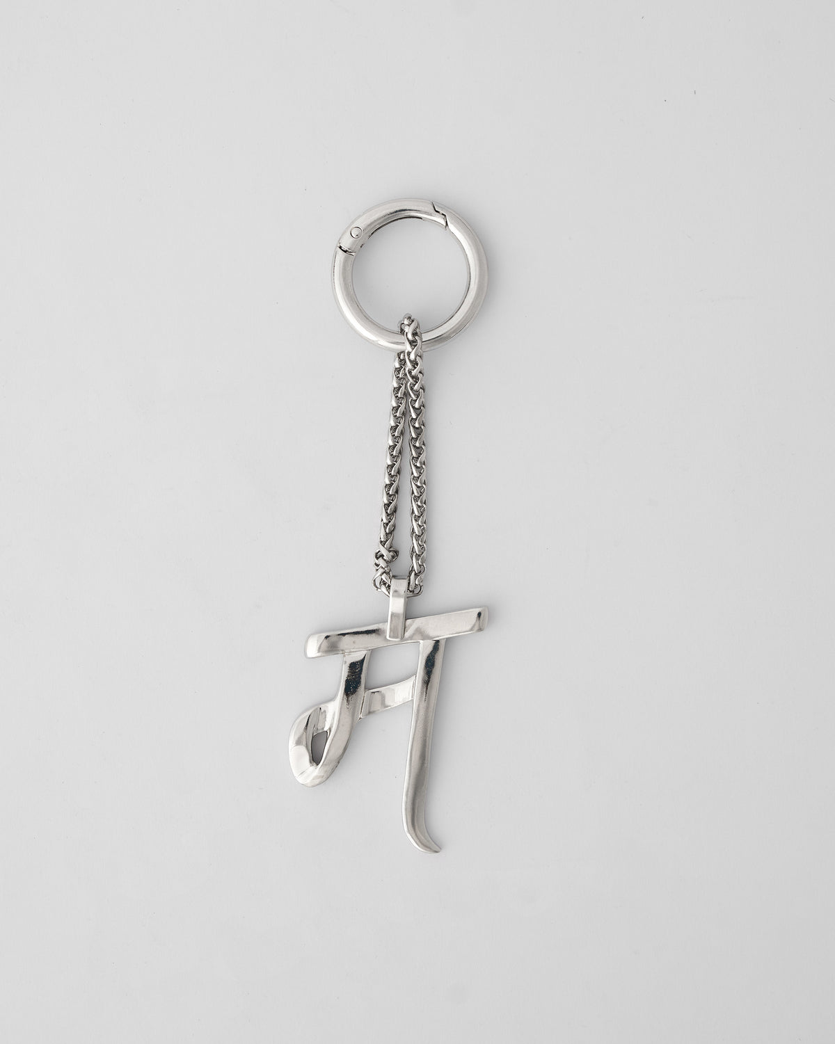 Alphabet M Bag Charm in silver hanging upright from its clasp ring.