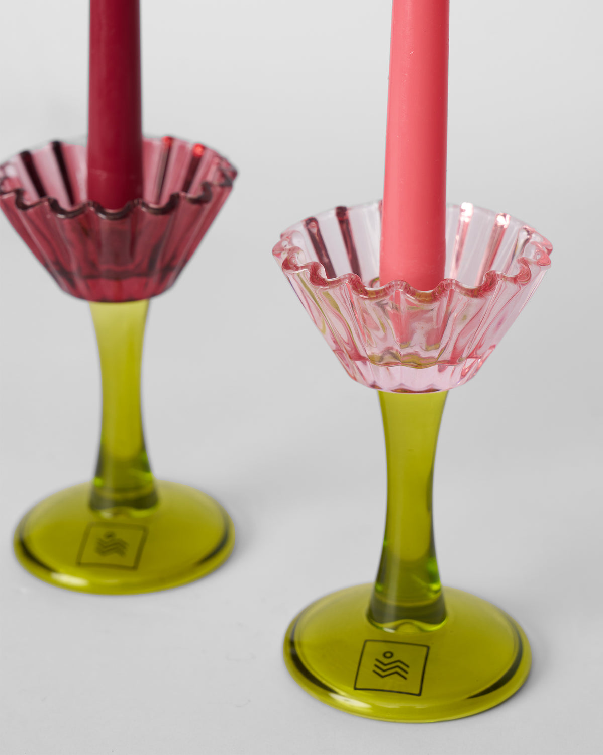 Close-up of Ember glass candle holders showing ruffled rims and lime green stems.