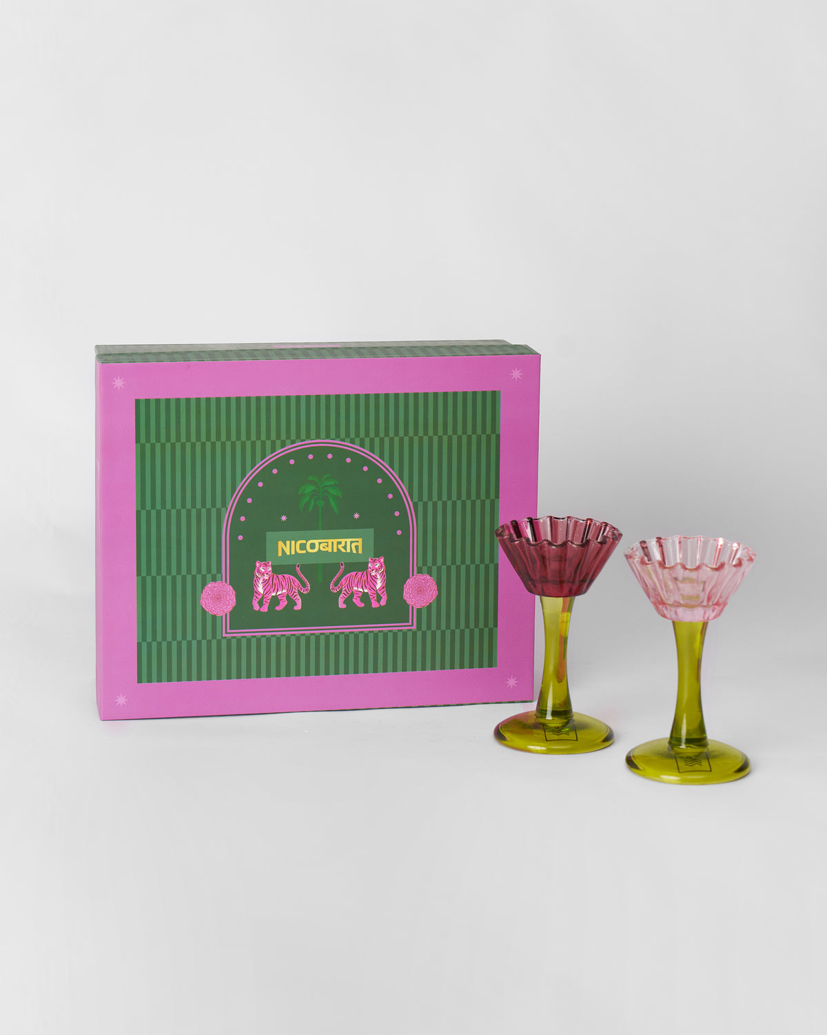 Ember Candle Holder and Taper Candle Set gift box beside a maroon and a pink fluted candle holder with olive stems.