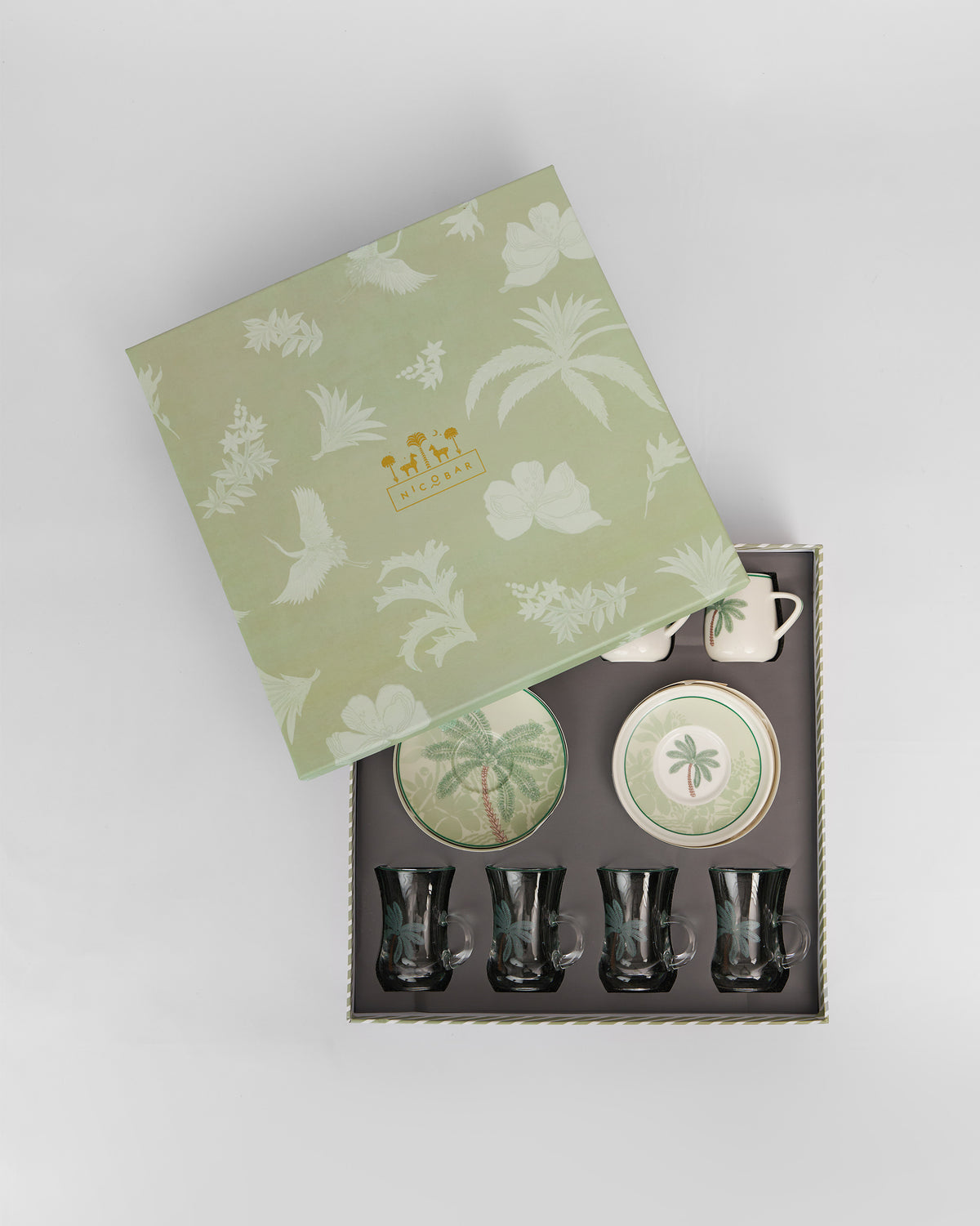 Veranda tea set in an open sage box with palm-printed cups and saucers.