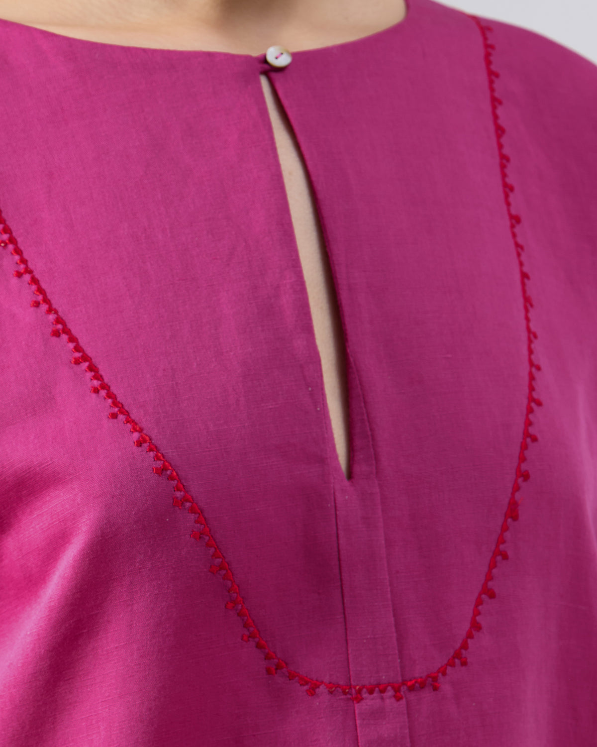 Close-up of the keyhole neckline on a berry pink Nihra Kaftan.