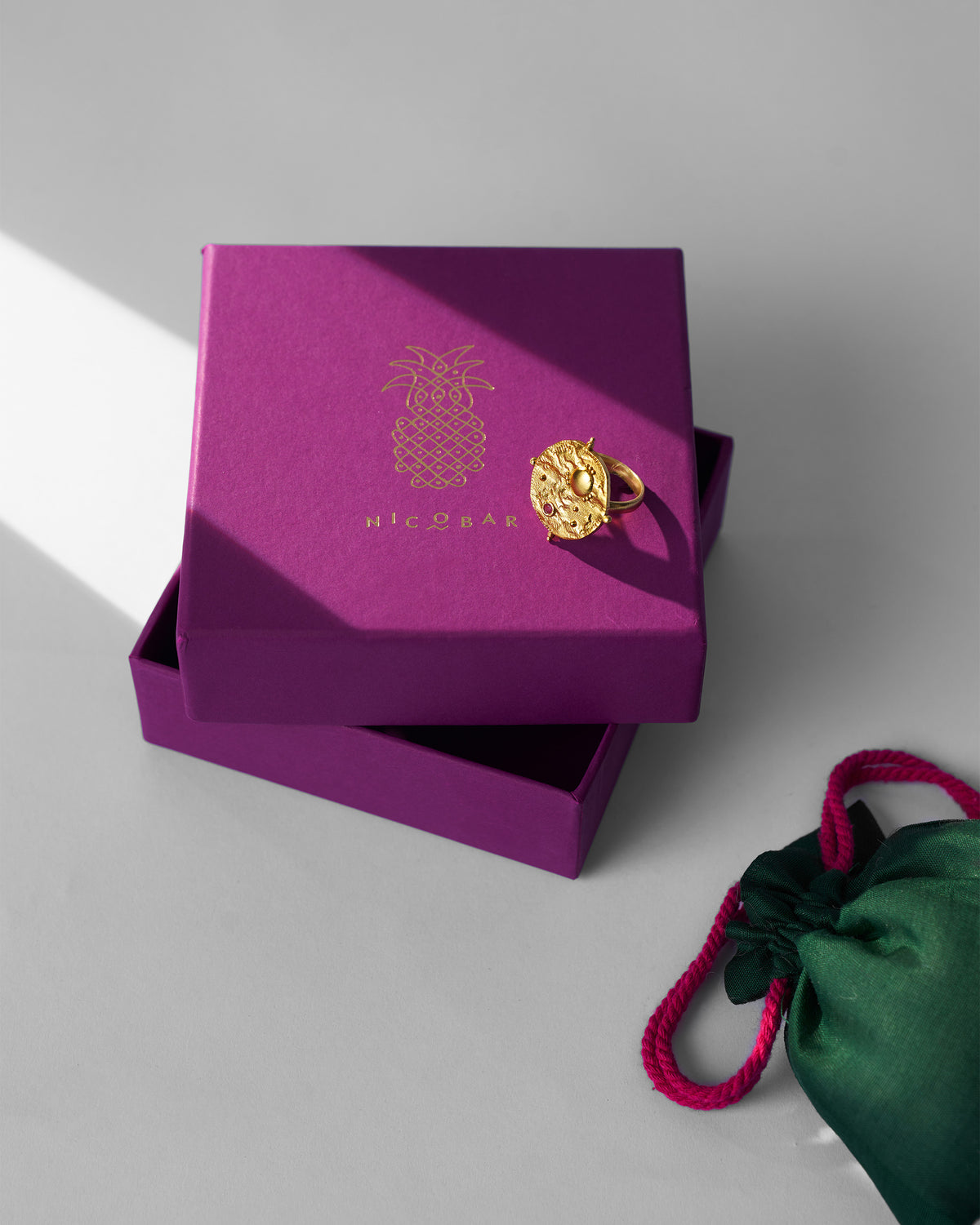 Gold Nebra ring on a purple Nicobar gift box.