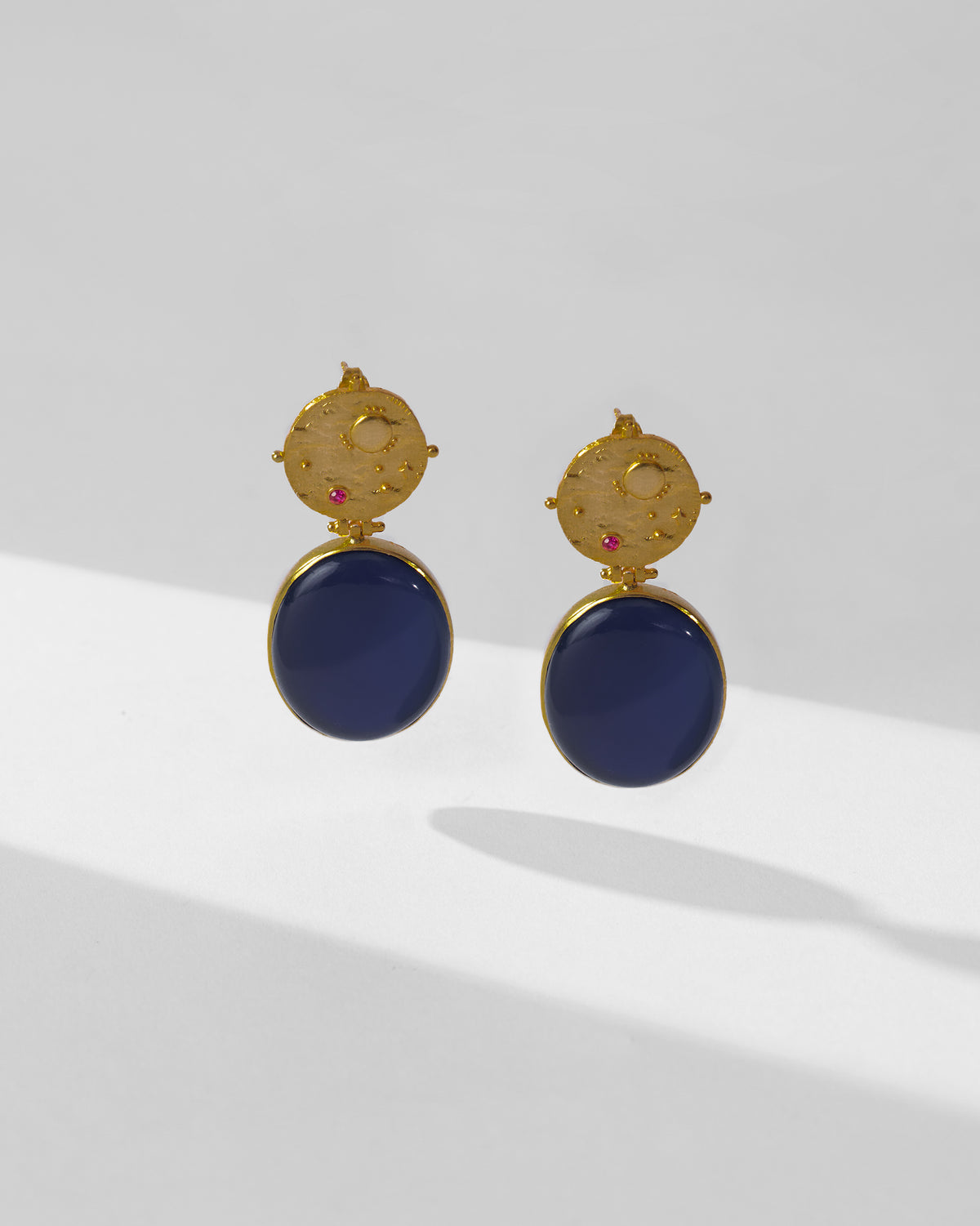 Pair of gold Nebra earrings with navy glass drops.