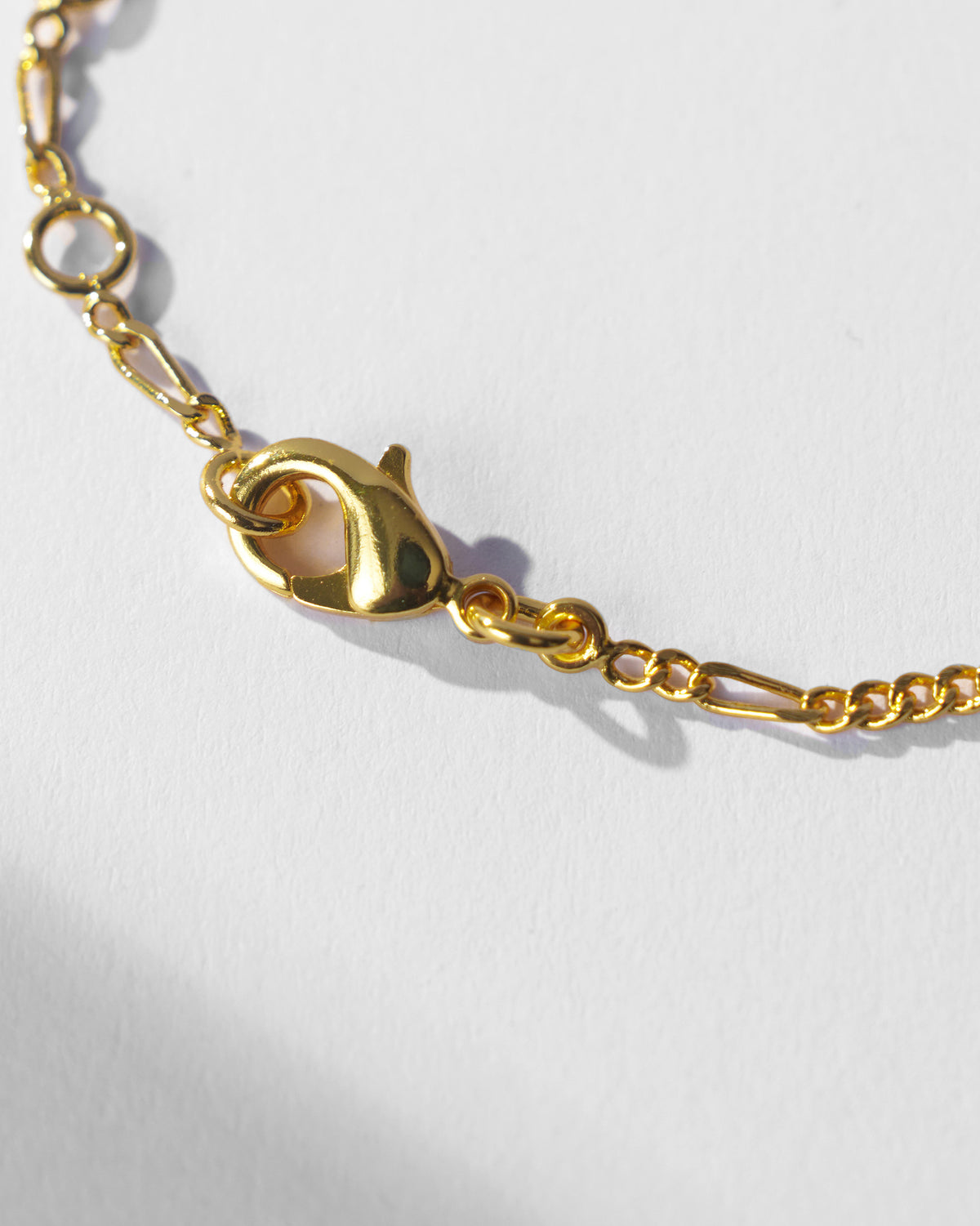 Close-up of the gold Maase bracelet lobster clasp and extension links.