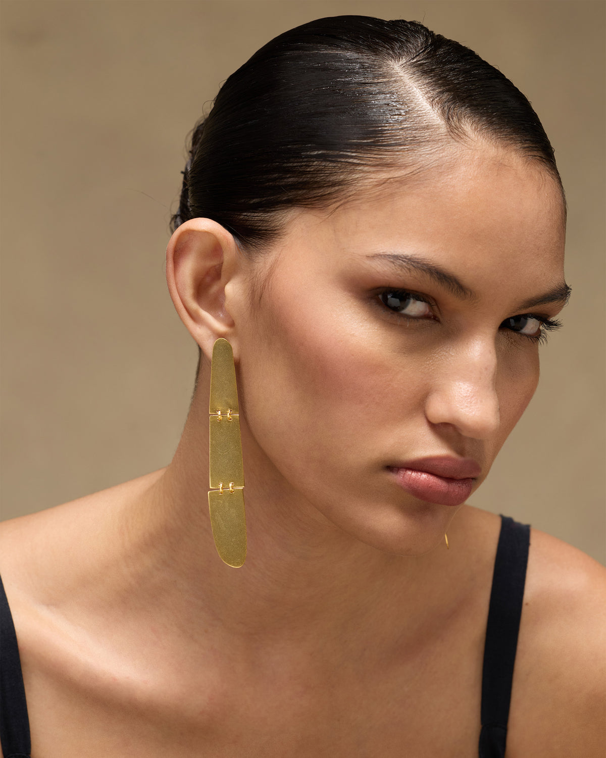 Person wearing a long gold Yamuna Earring.