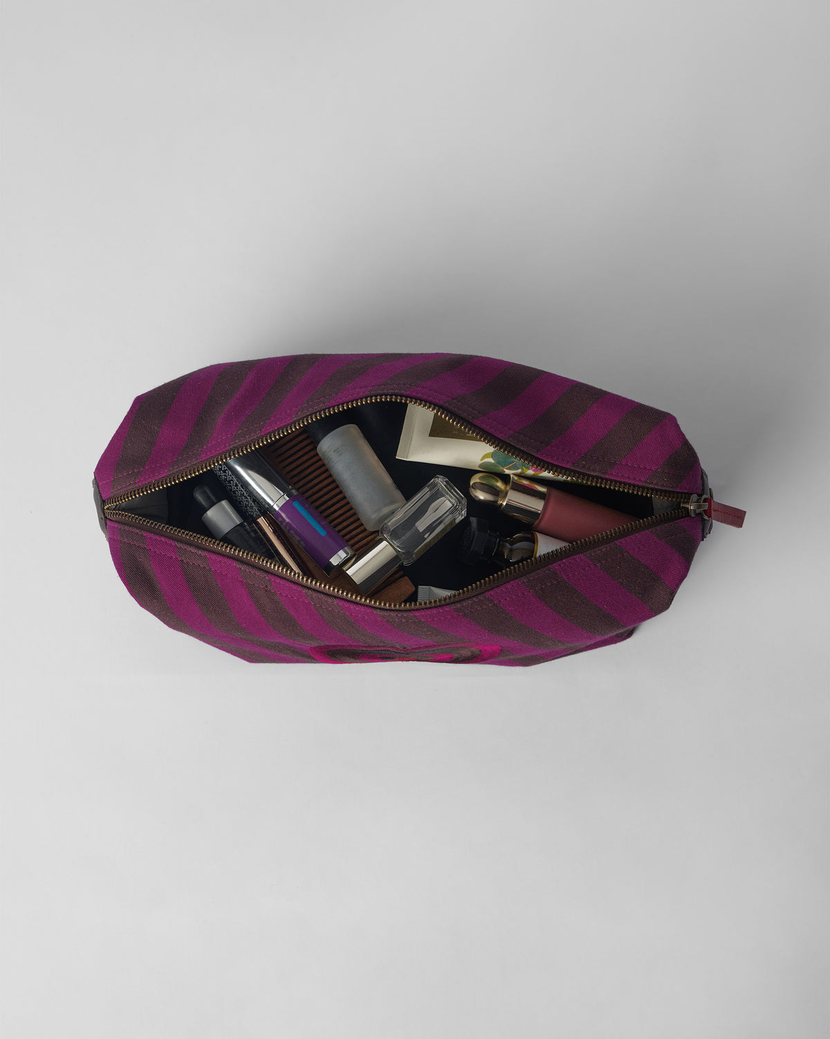 Open Cupid Pouch packed with bottles and everyday cosmetics.