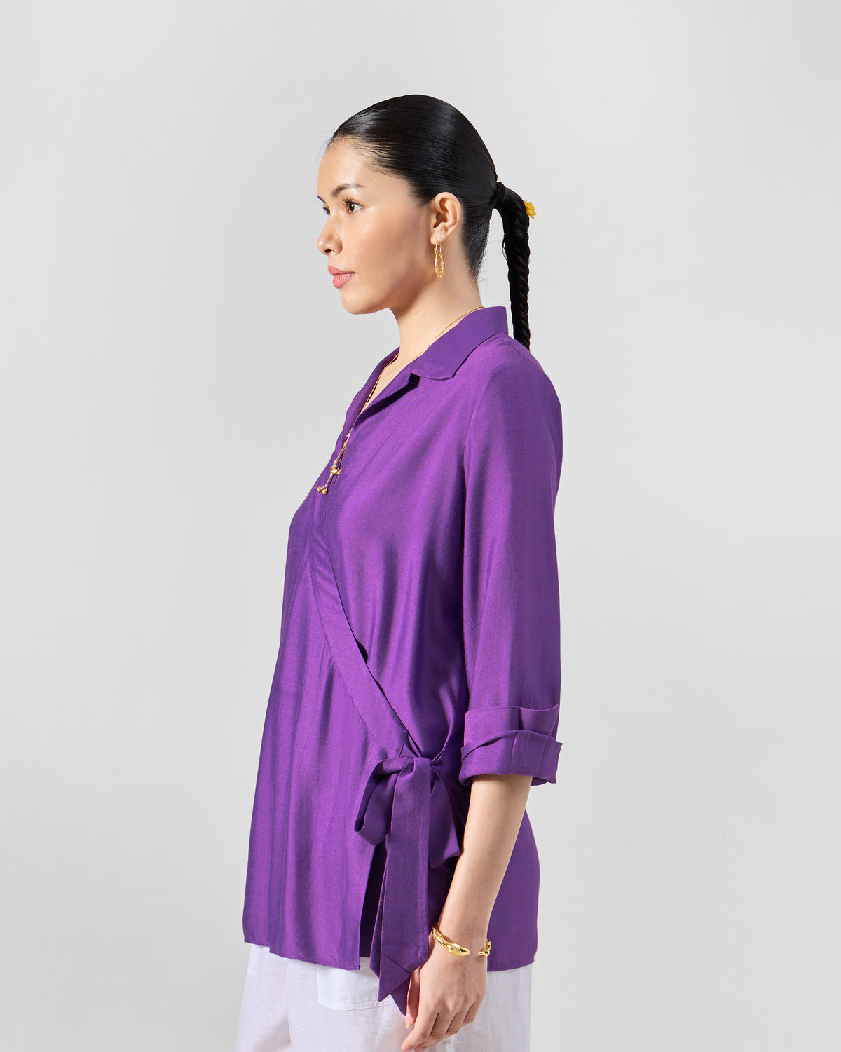 Side view of a purple Katya shirt showing the wrap front and hip tie.