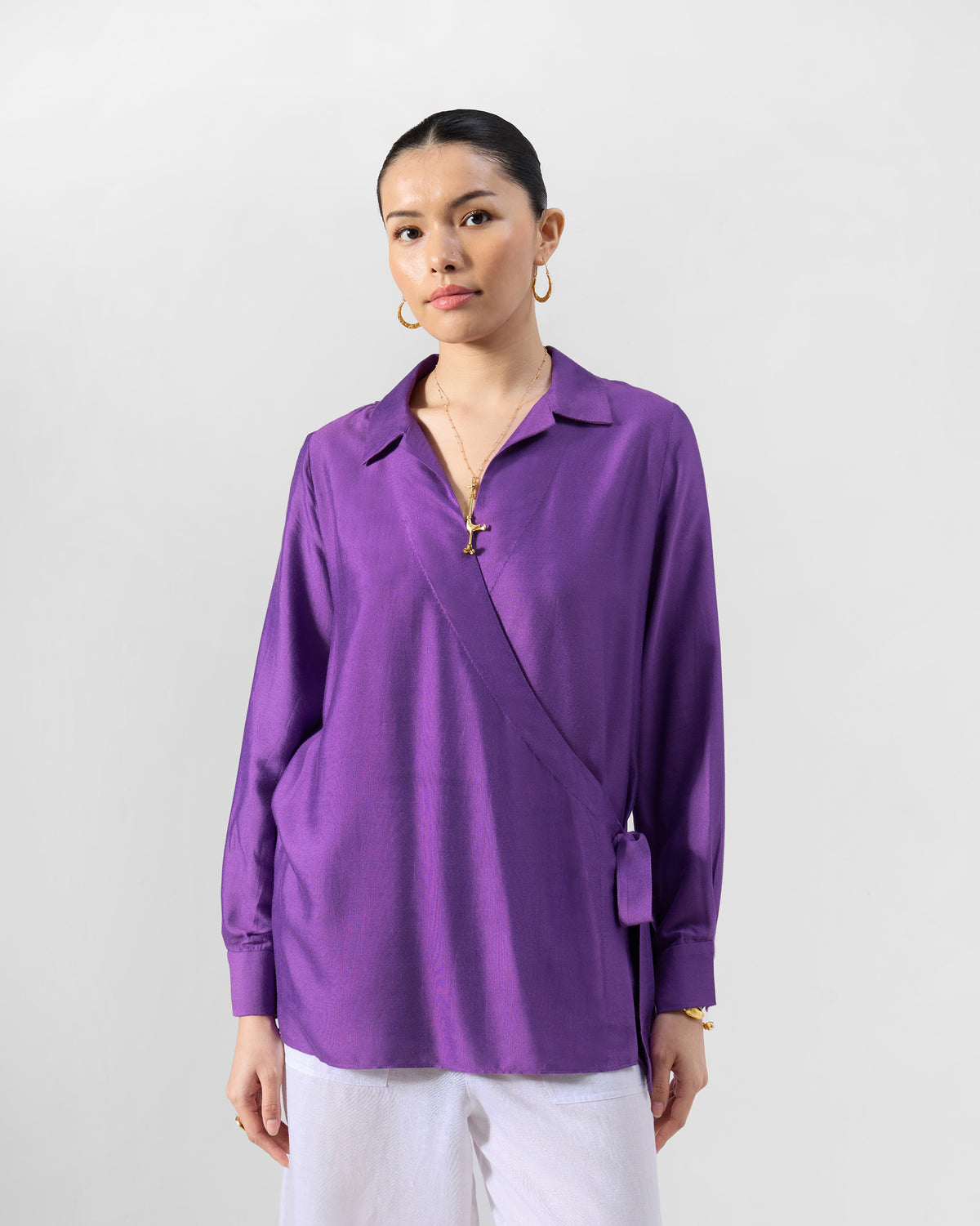 Person wearing a purple Katya wrap shirt with a deep V neckline.