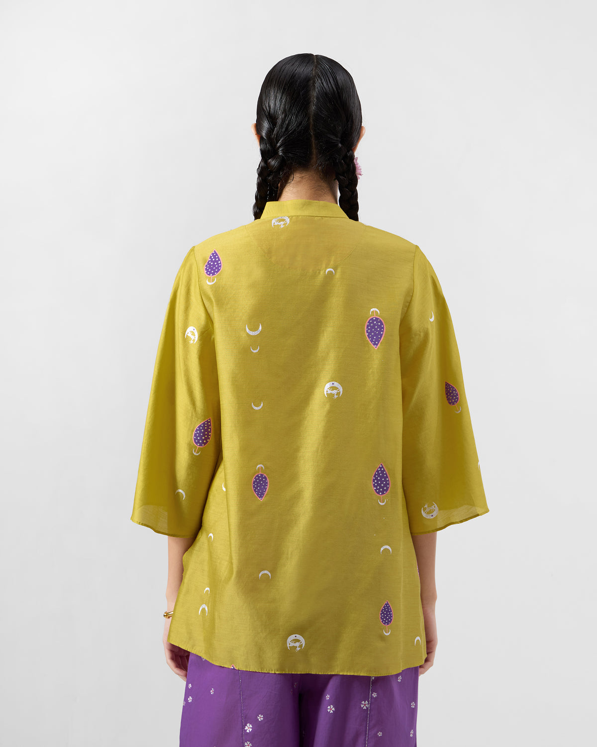 Back of a chartreuse Chilika shirt with purple teardrop motifs.