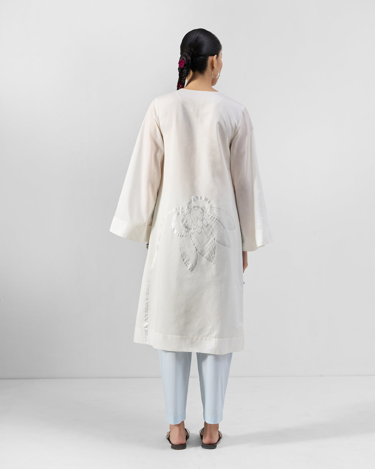 Back of an ivory Vaya kurta with a lotus motif at the lower back.