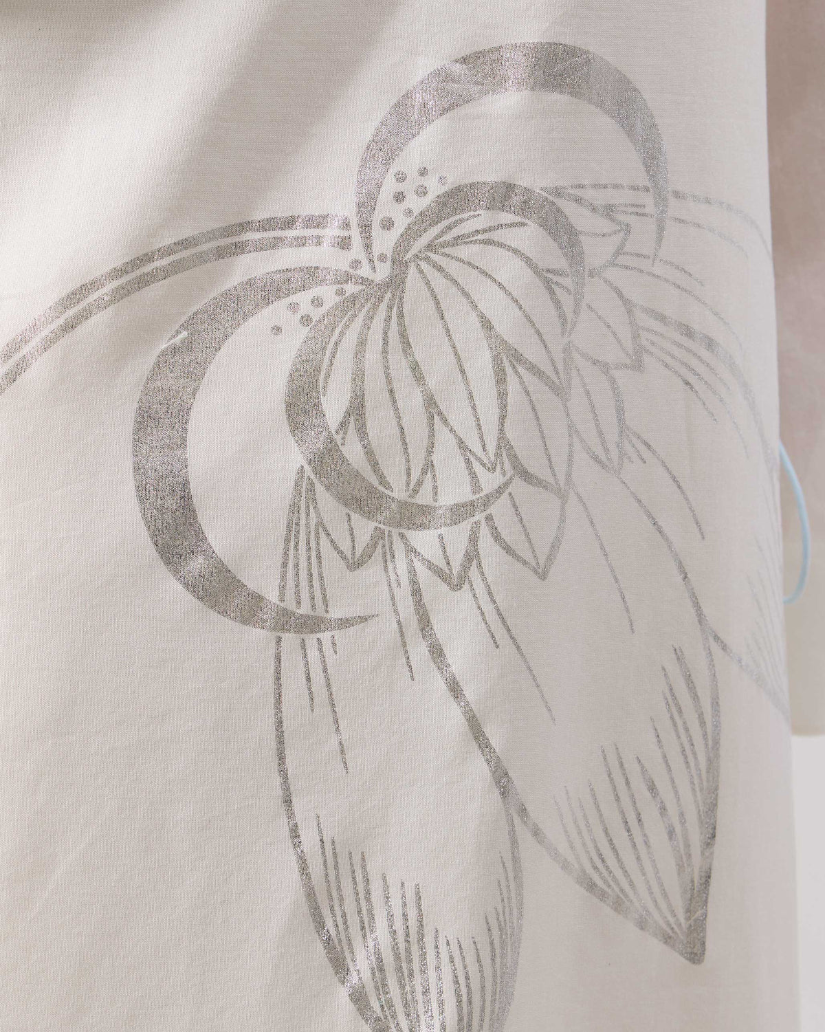 Close-up of the silver lotus foil print on an ivory Vaya kurta.
