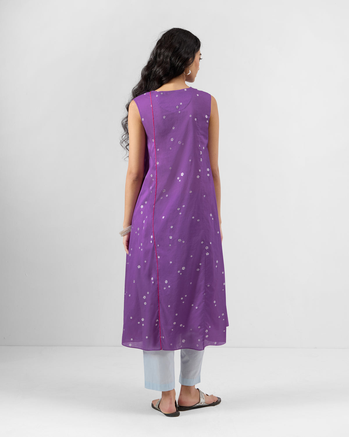 Back of a purple printed Tuni kurta with a pink side seam.
