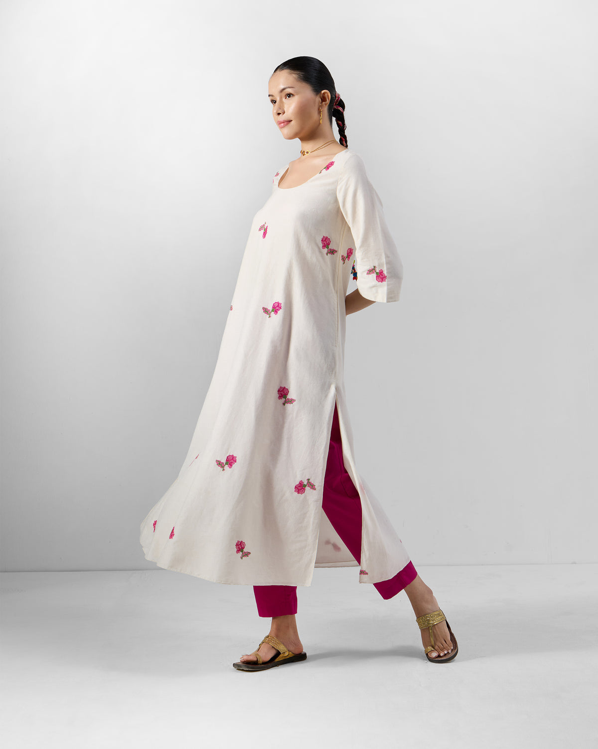 Person wearing a cream Amrai Kurta with scattered pink floral embroidery.