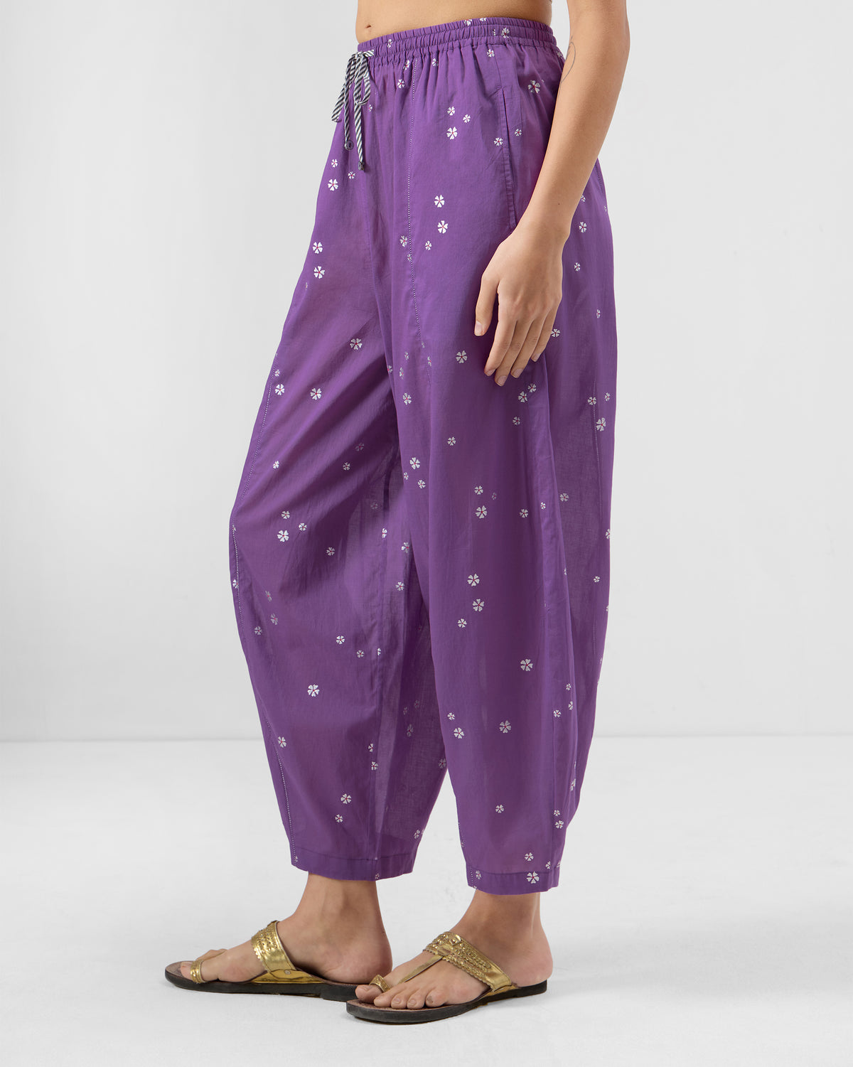 Side view of purple floral Bora pants with a relaxed fit tapering at the ankle.