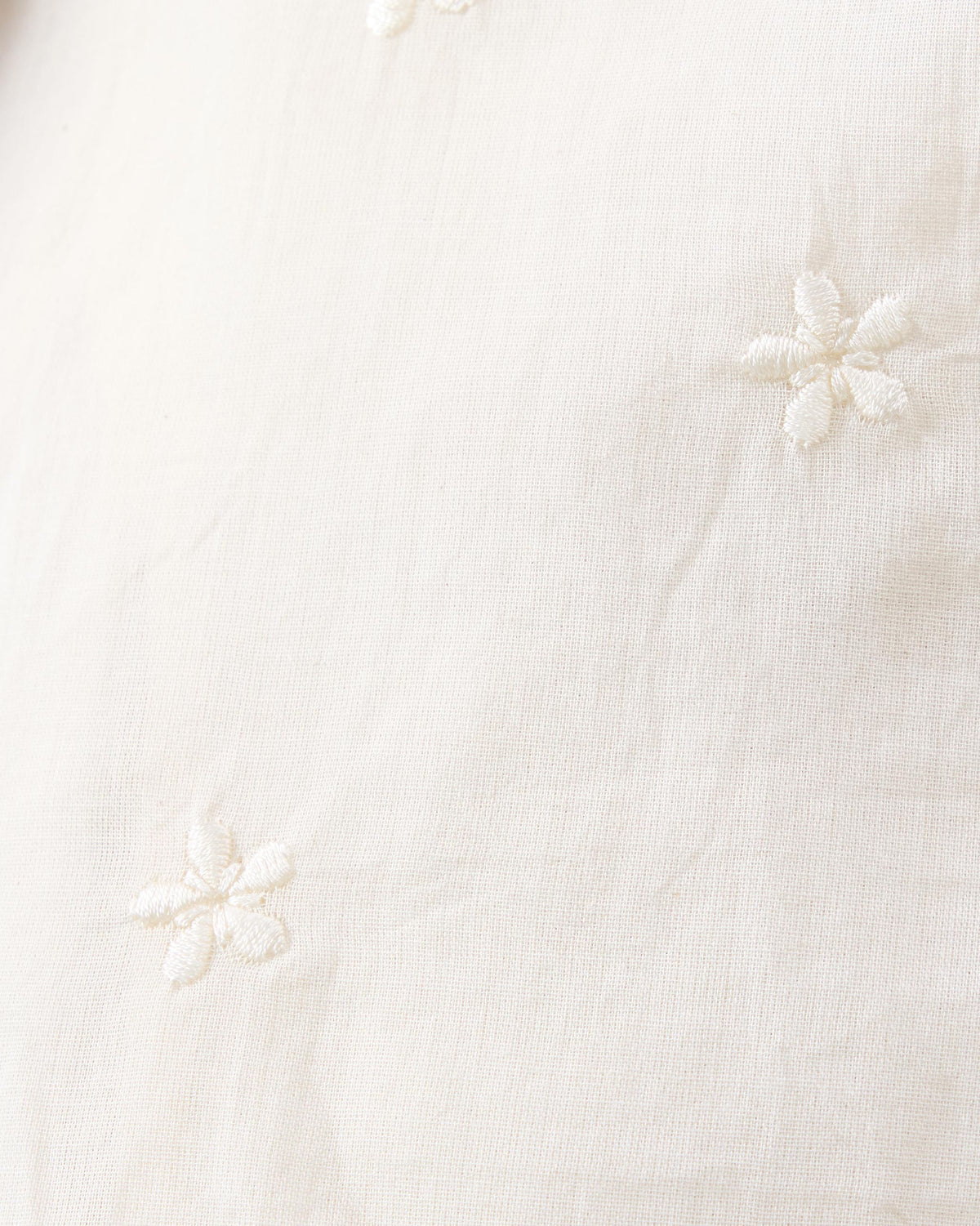 Close-up of ivory Lola slip fabric with tone-on-tone embroidered flowers.