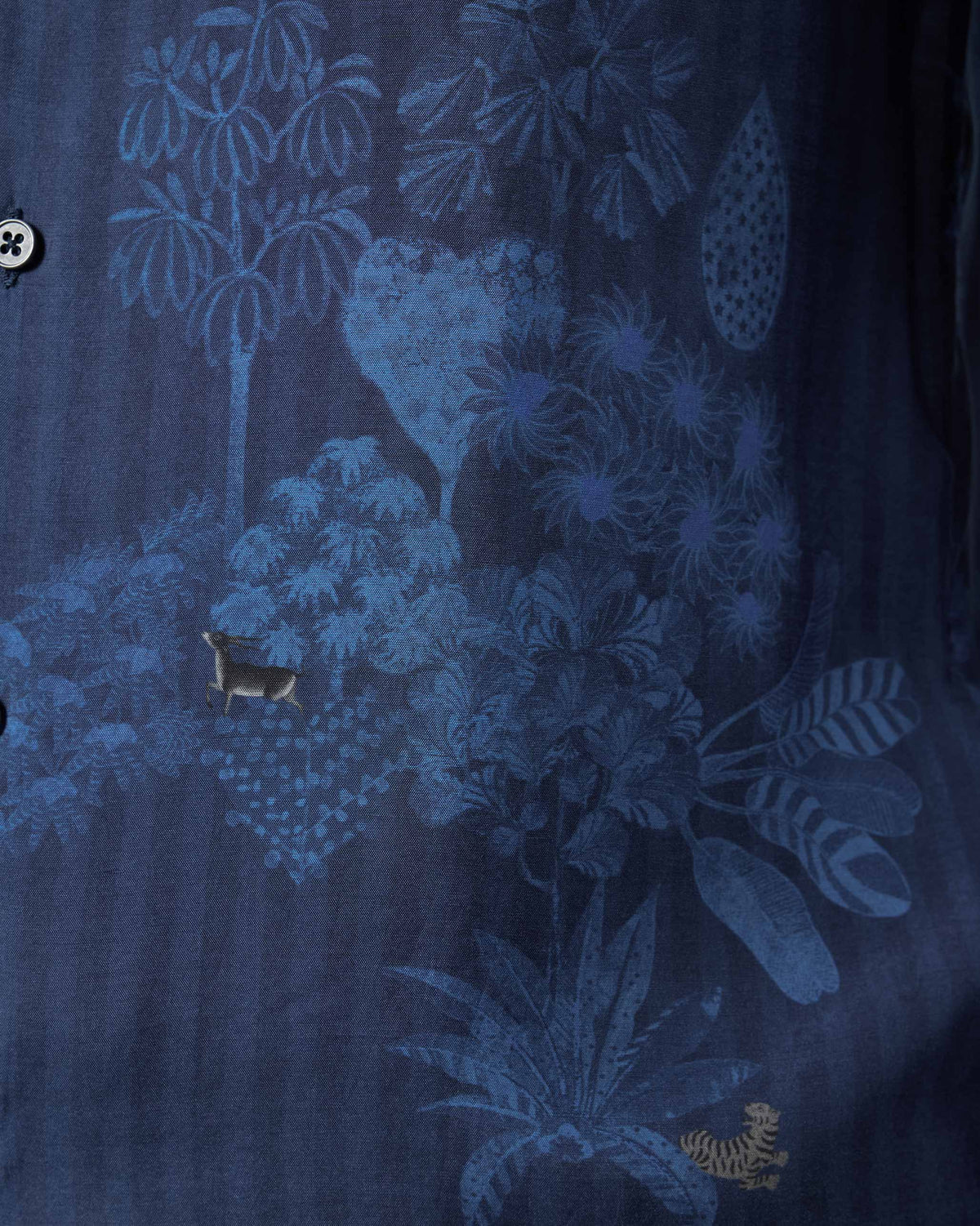 Close-up of a navy Hakuna shirt showing a tonal blue jungle print.