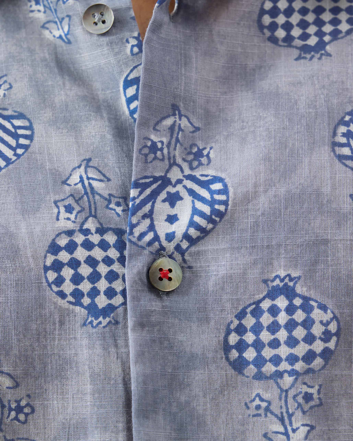 Close-up of a Ganga Shirt placket with block print and a red-stitched button.