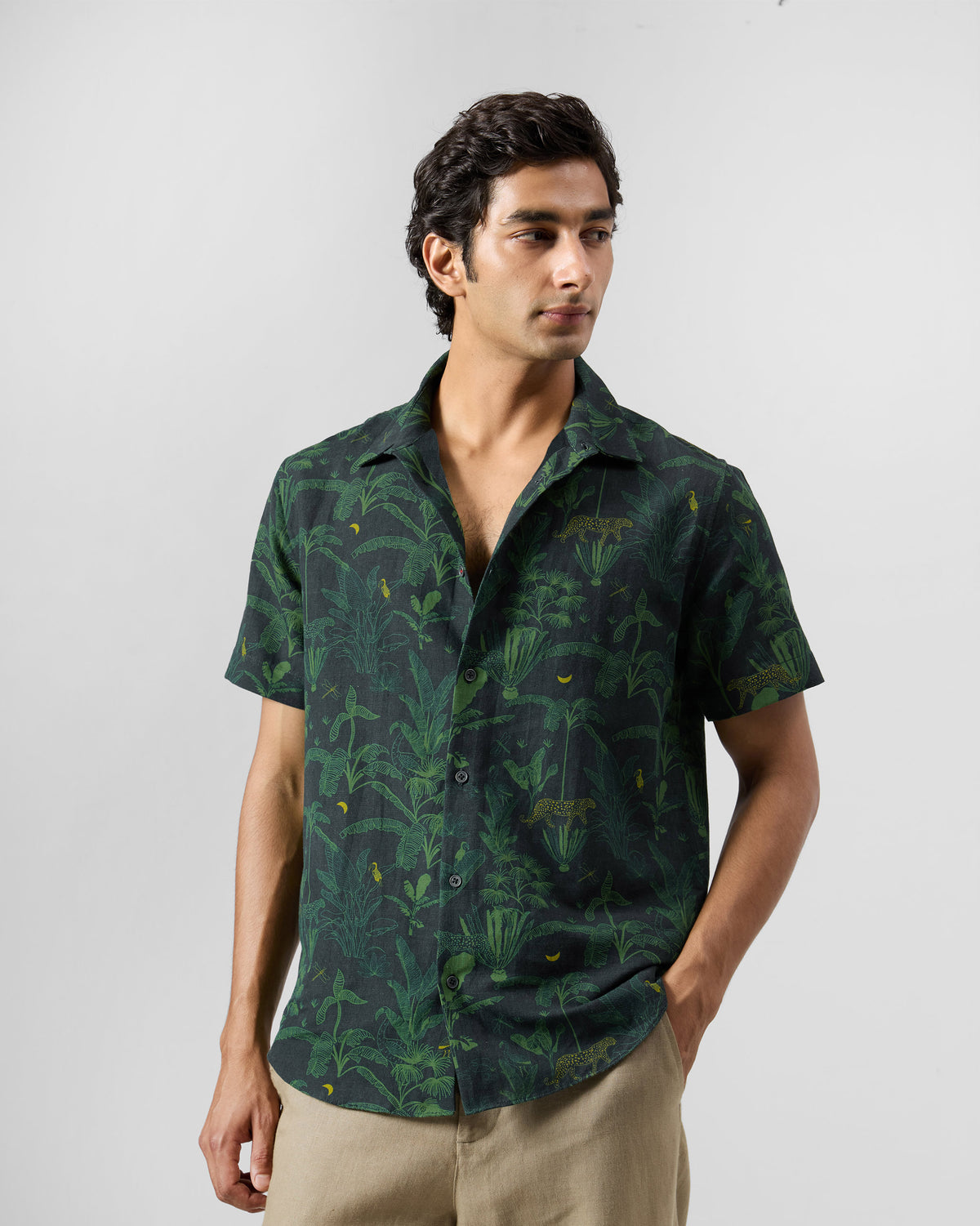 Person wearing a green Half Sleeve Shirt with jungle foliage and leopard motifs.