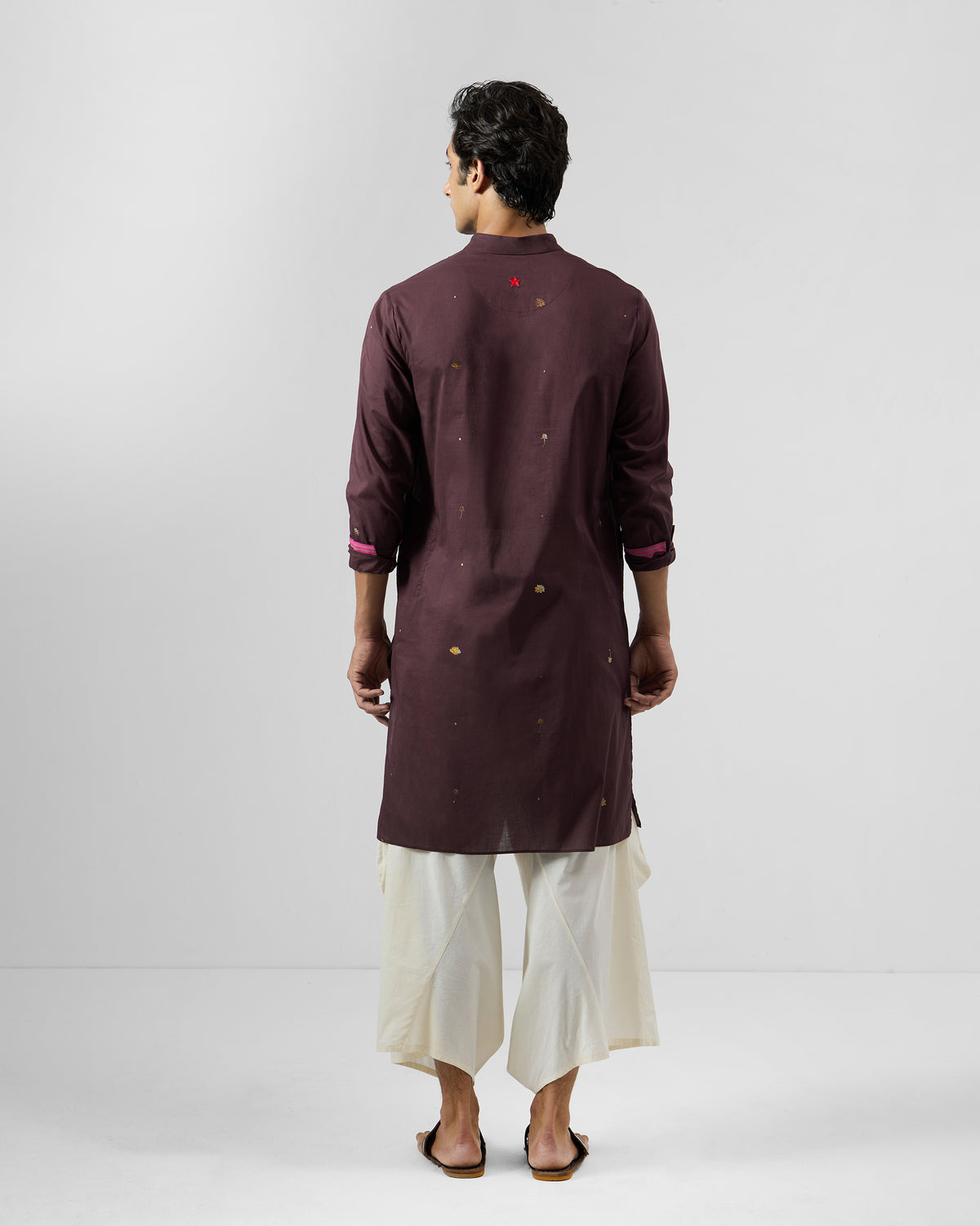 Back of a wine Rey Kurta with gold motifs and pink cuff lining.