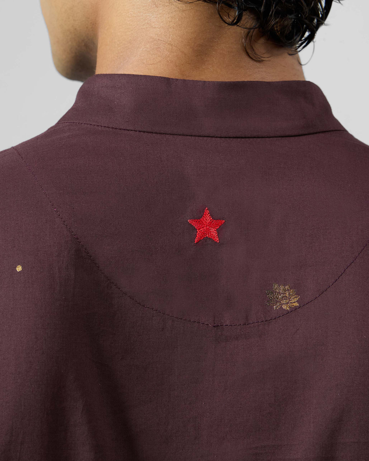 Close-up of the red embroidered star on the back of a wine Rey Kurta.