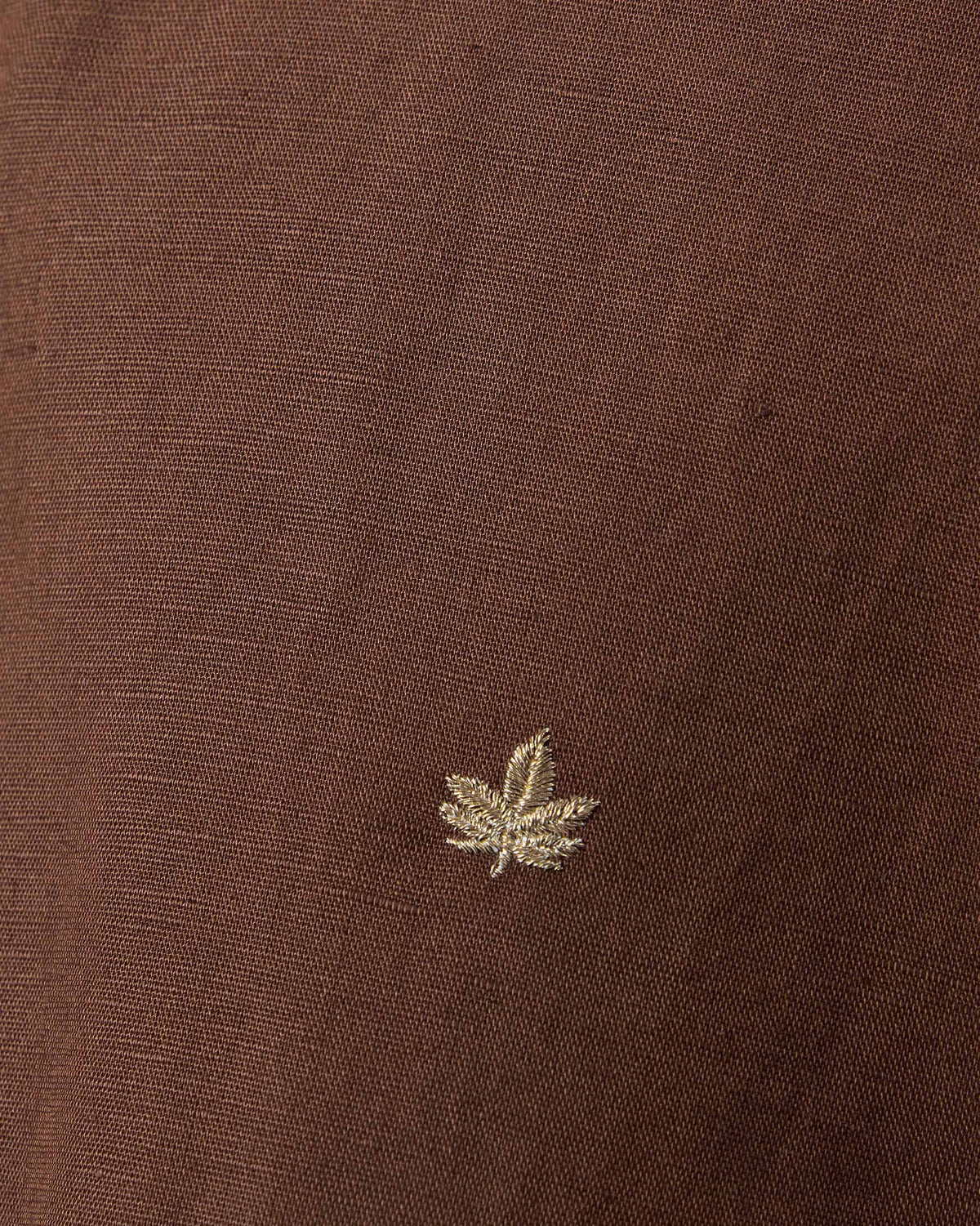 Close-up of brown Astral kurta fabric showing a chinar leaf embroidery.