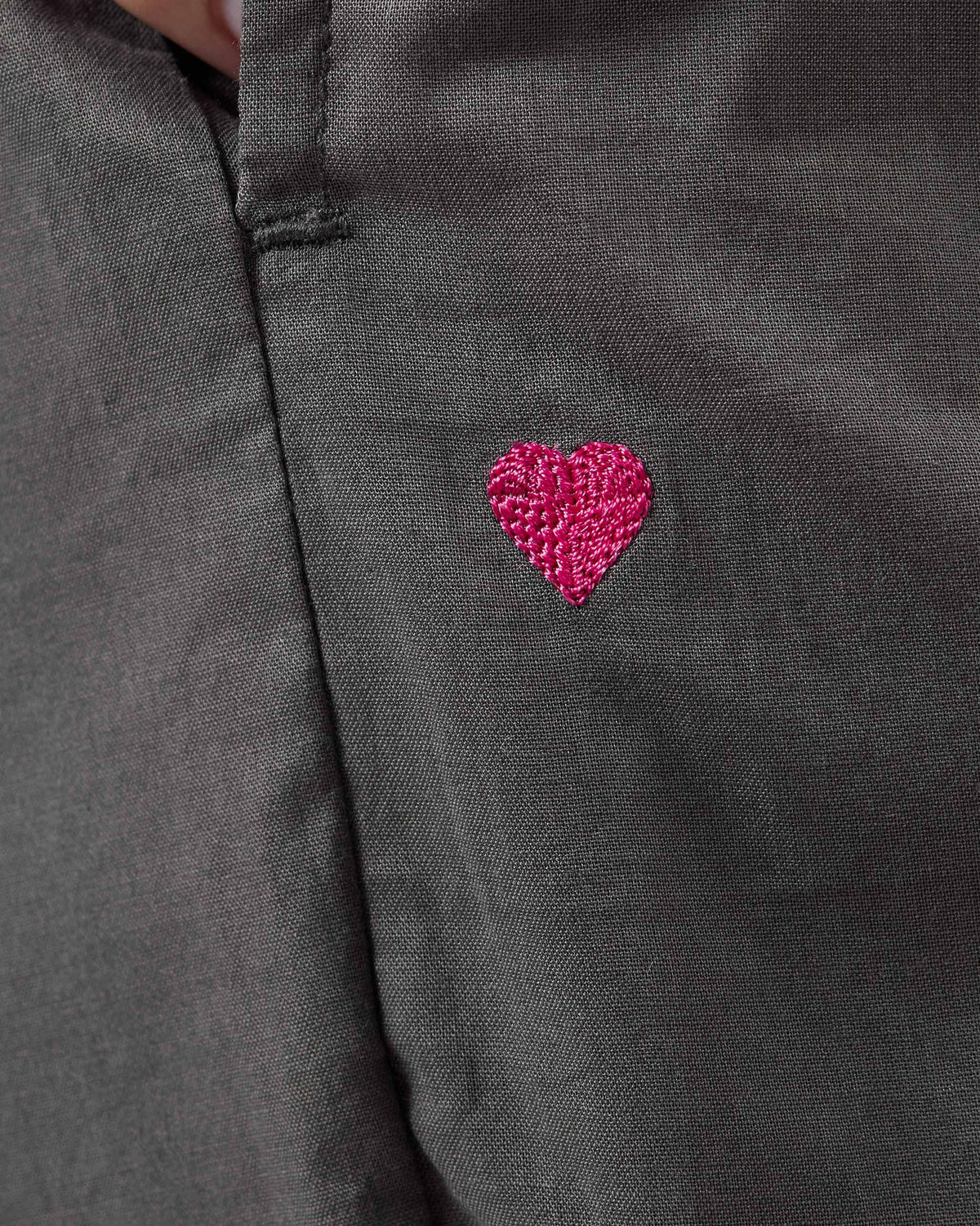 Close-up of a pink heart embroidered on charcoal Narrow Pants.