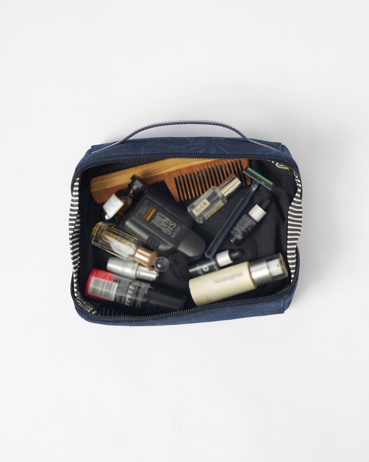 Open navy Palm dopp kit filled with toiletries.