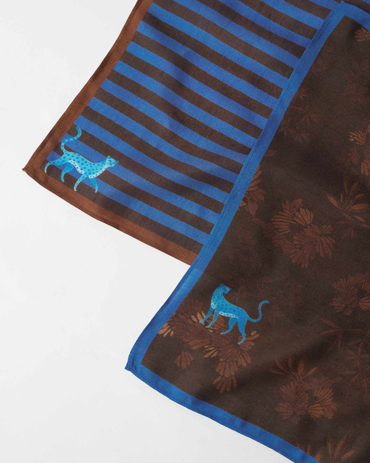 Close-up of blue tiger motifs on brown-and-blue striped and botanical pocket squares.
