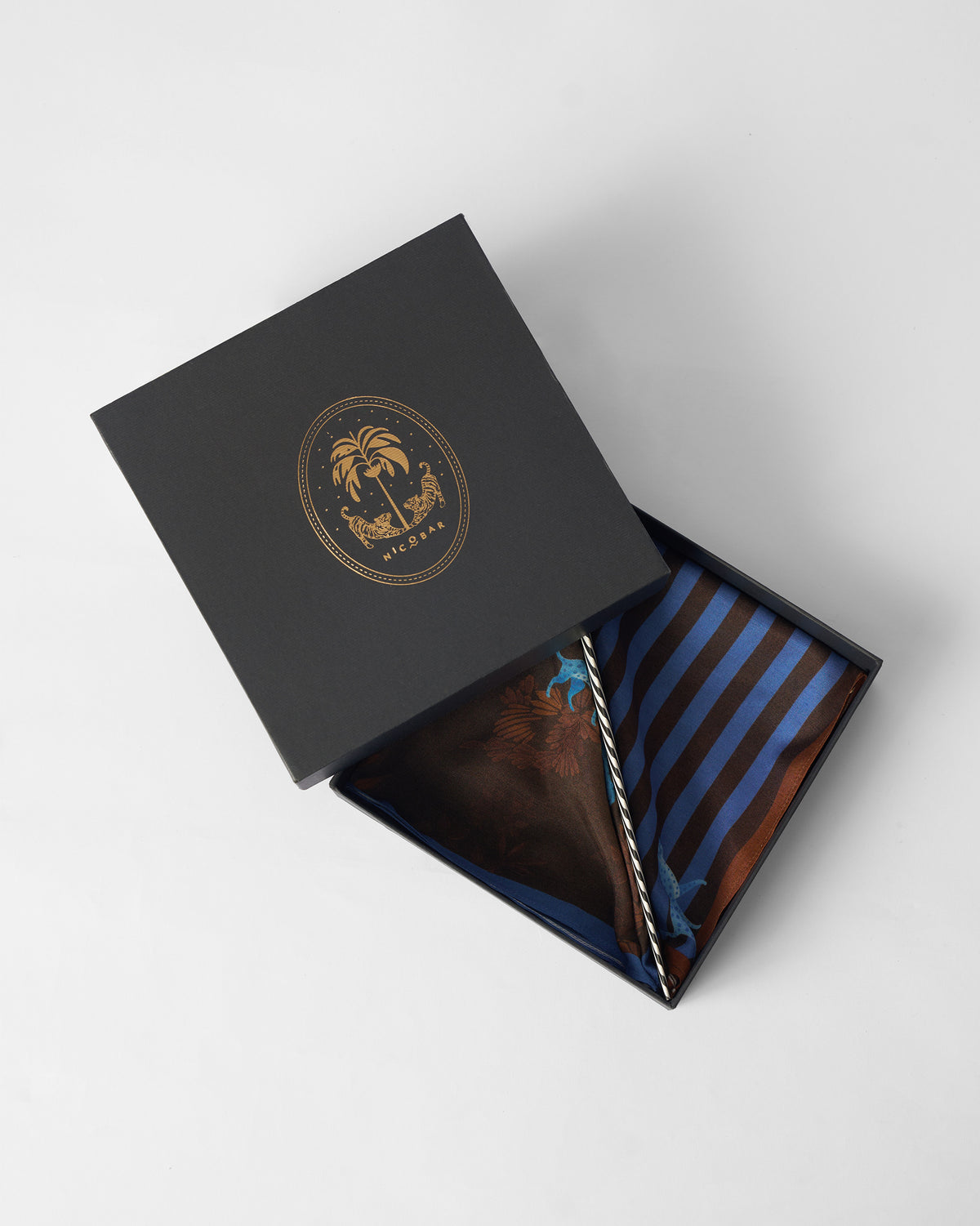 Stripey Tiger pocket squares folded in an open black Nicobar gift box.