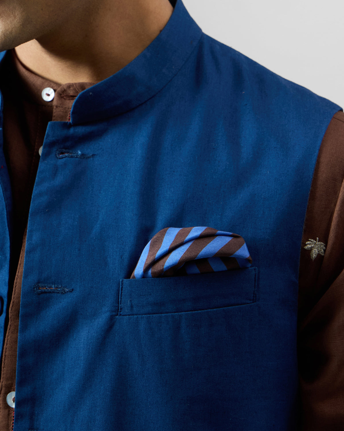 Blue and brown striped tiger pocket square in a blue Nehru vest pocket.