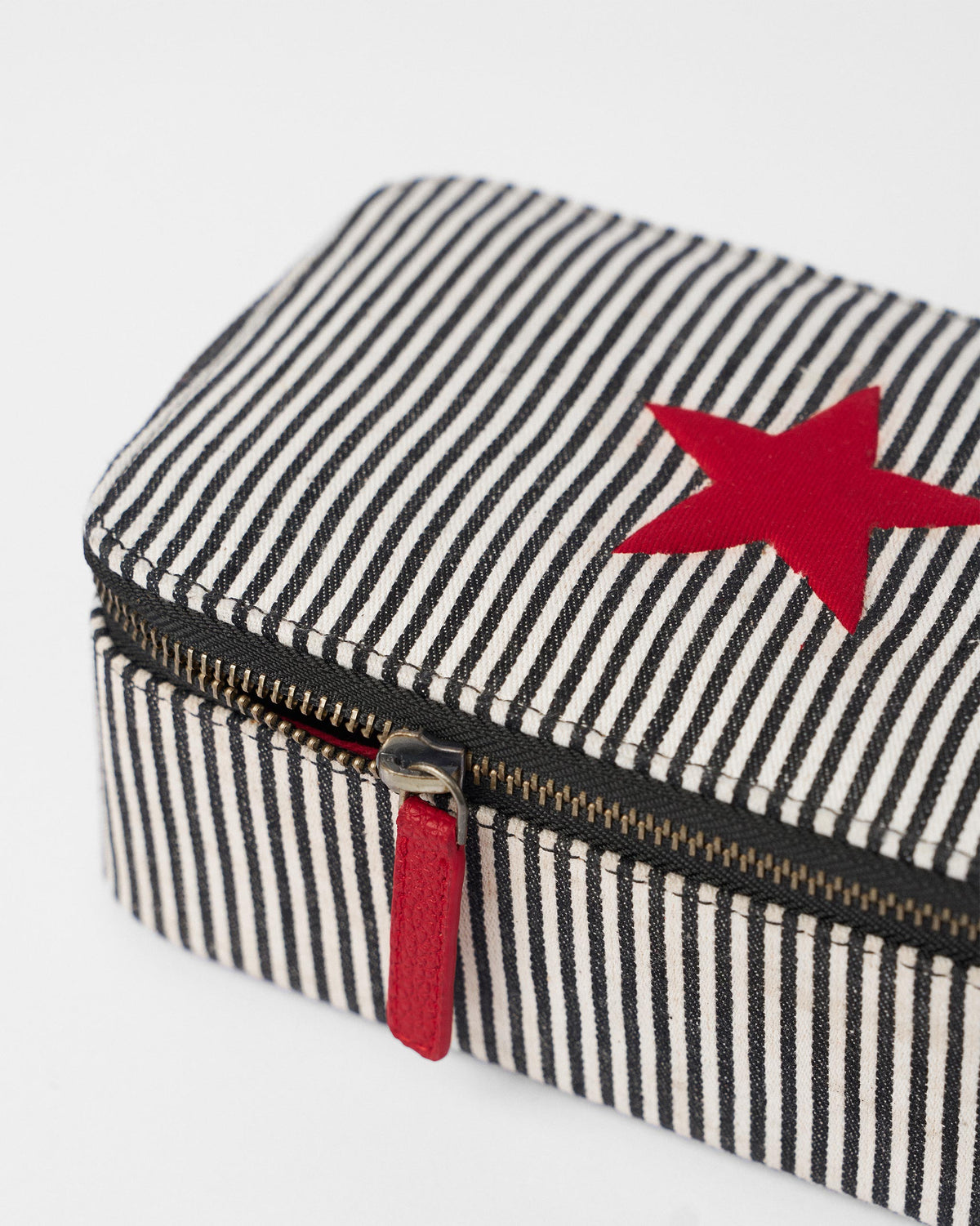 Close-up of the red star and red zipper pull on the striped organiser.