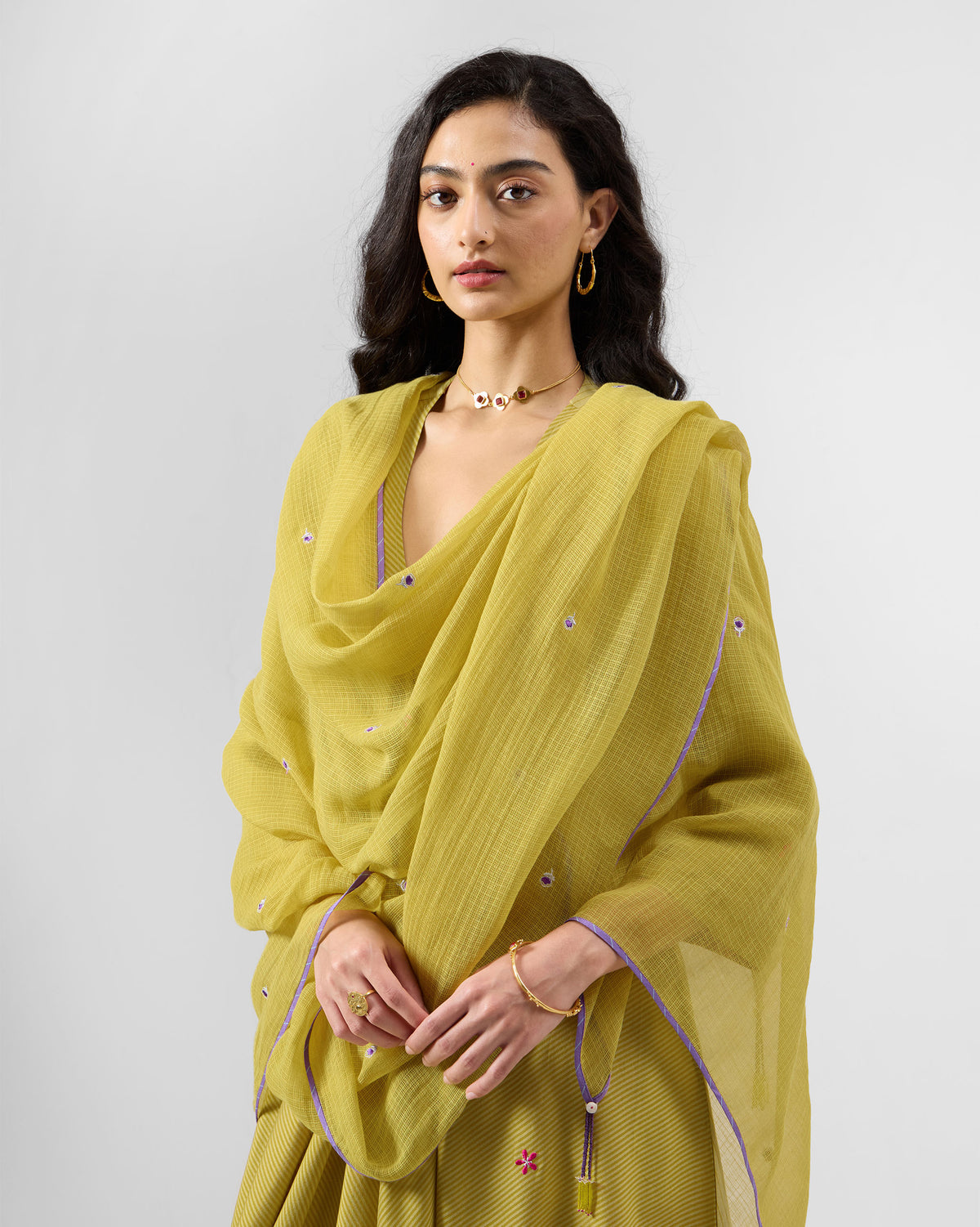 Person wearing a chartreuse Raya dupatta draped over the shoulders.